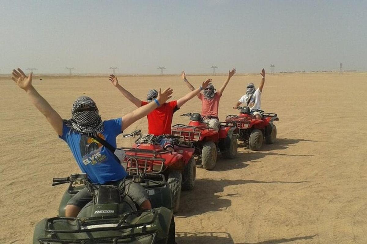 sekelompok orang mengendarai ATV di padang pasir