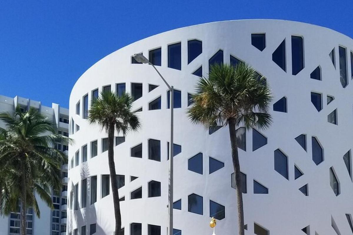 Un edificio blanco con palmeras delante.