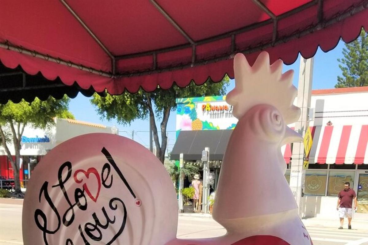 Un pollo y un cartel delante de una tienda de campaña.