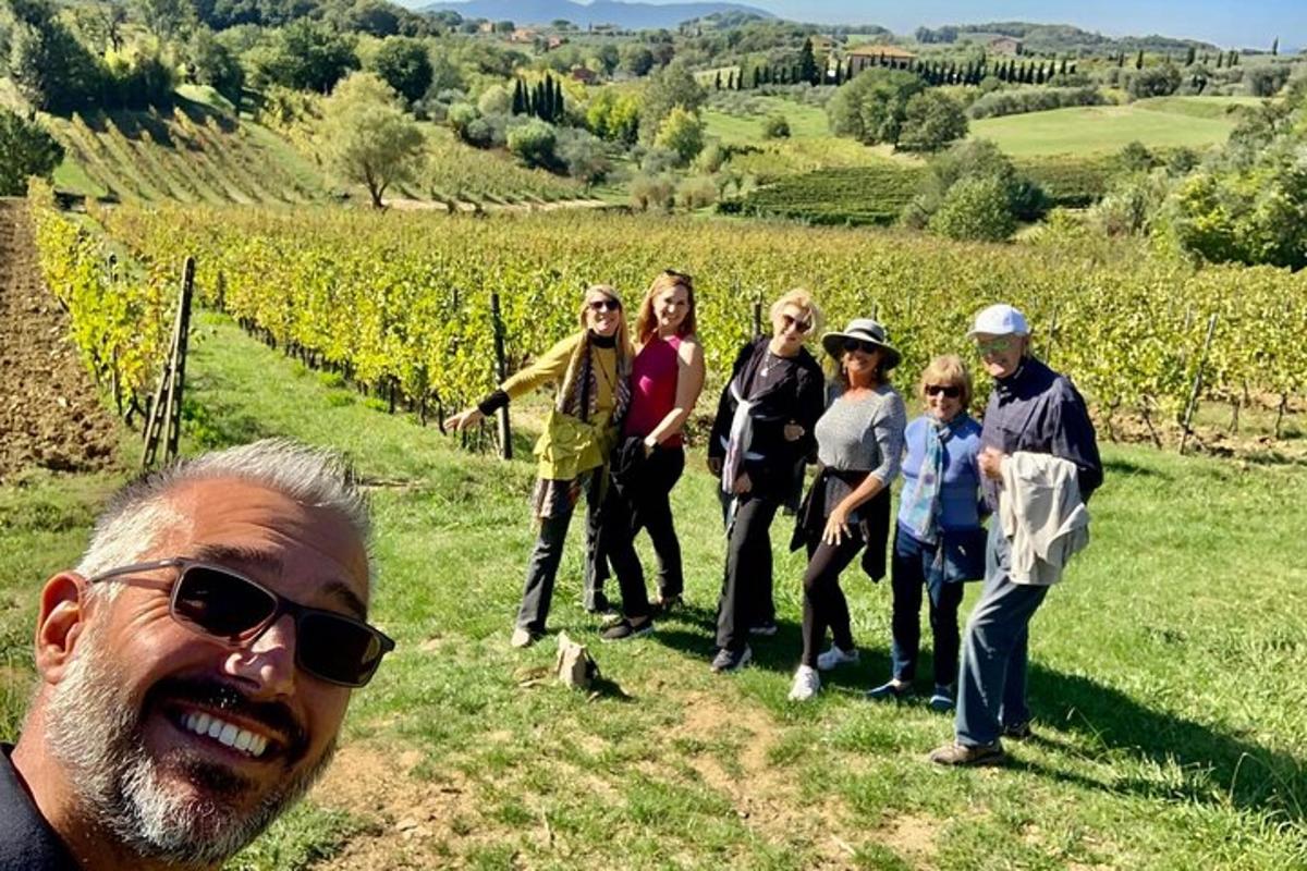a group of people standing in front of a vineyard