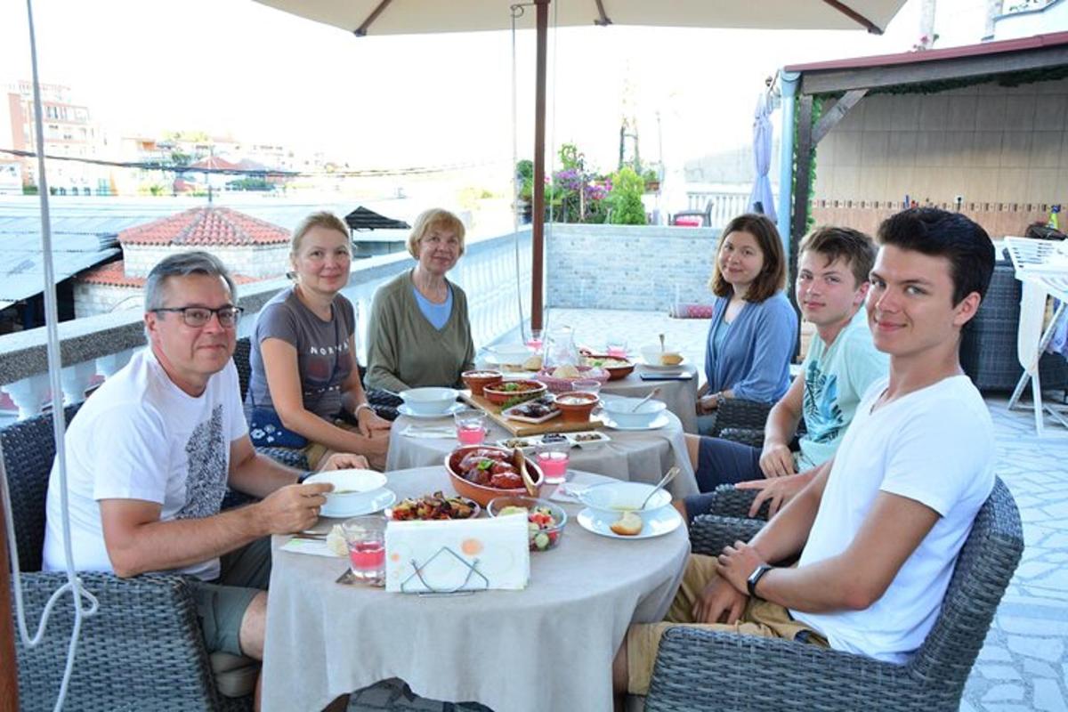 grupa ljudi koji sjede oko stola s hranom