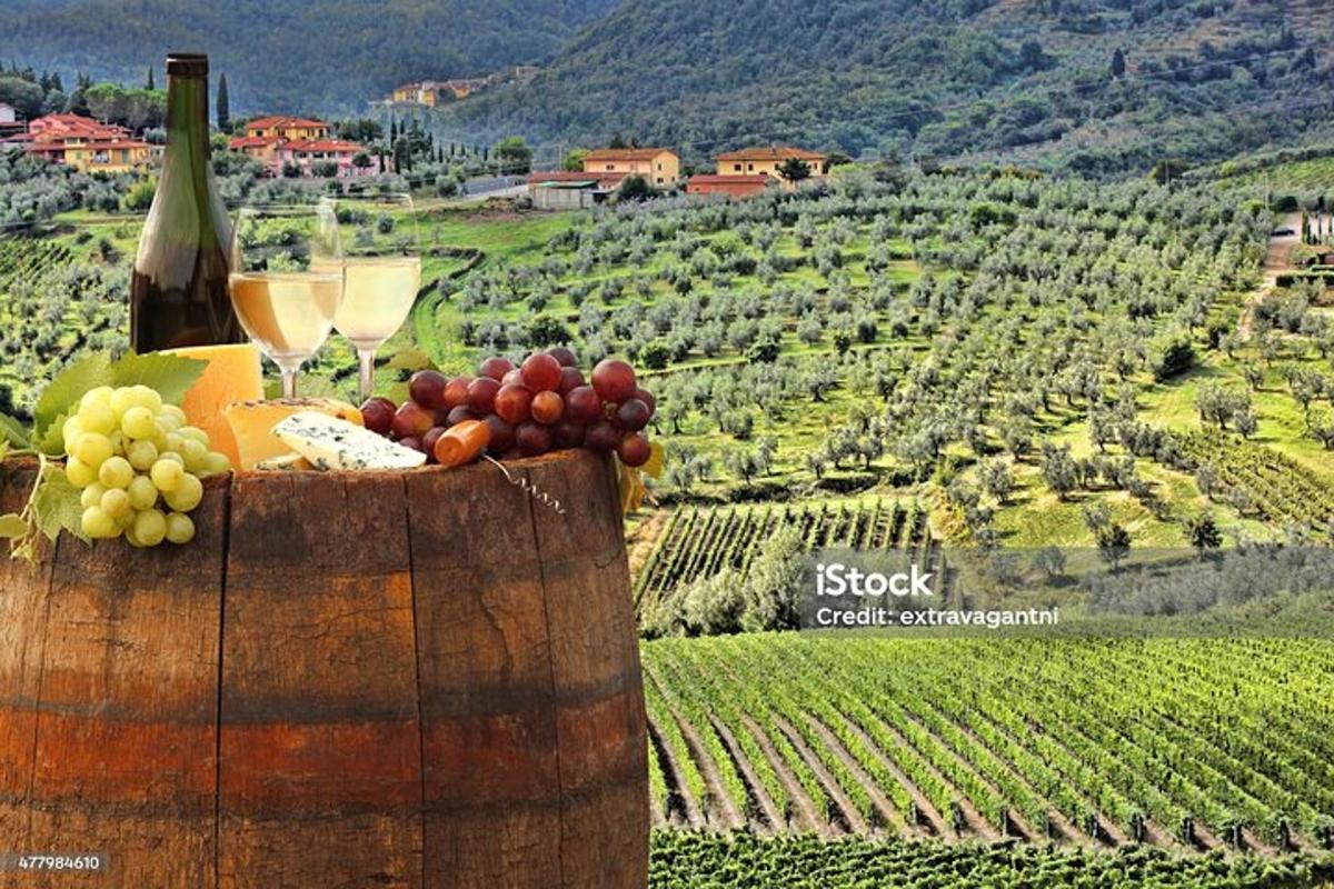 uma garrafa de vinho e um cacho de frutas em um barril