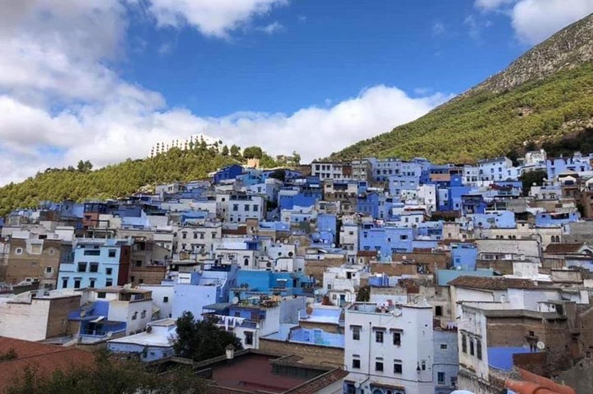 sebuah kota dengan bangunan biru dan putih di atas bukit