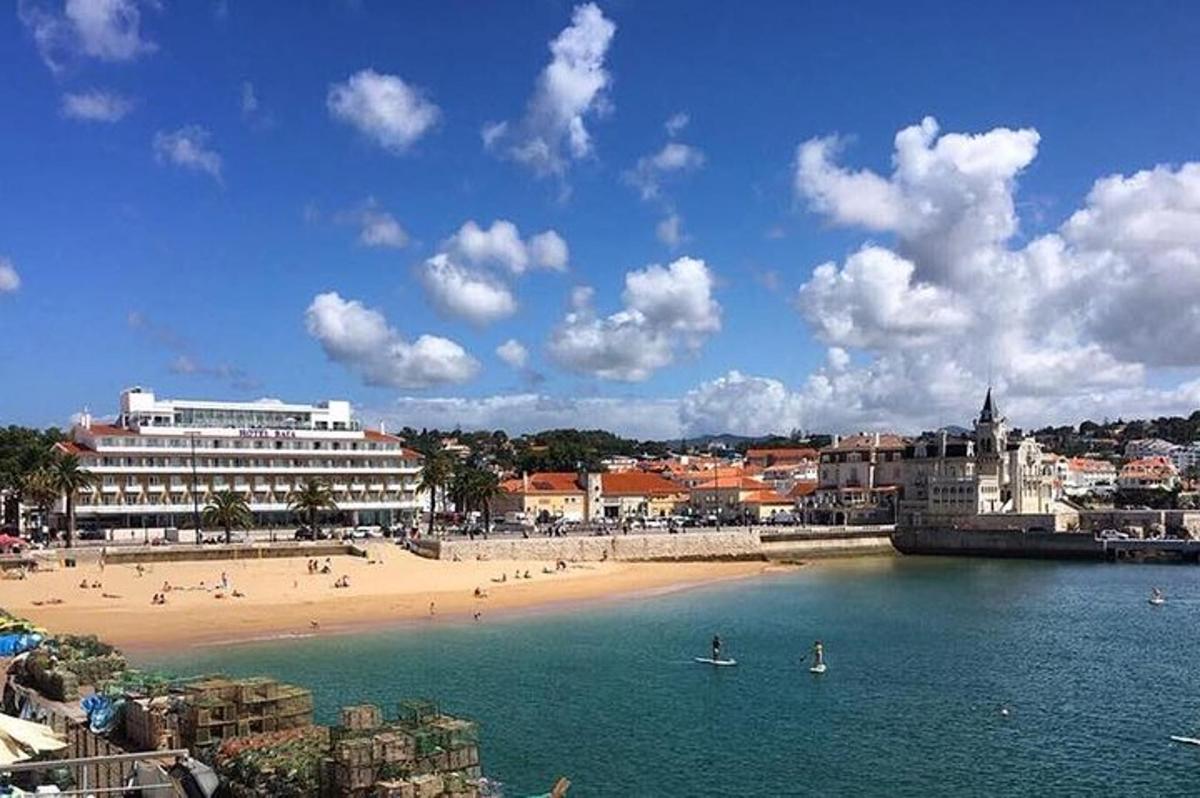 uma praia com pessoas na água e um prédio