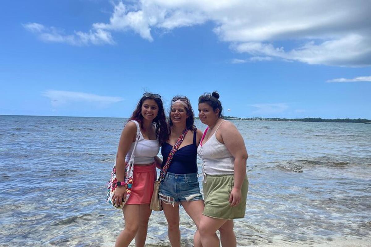 three women standing on the beach near the water