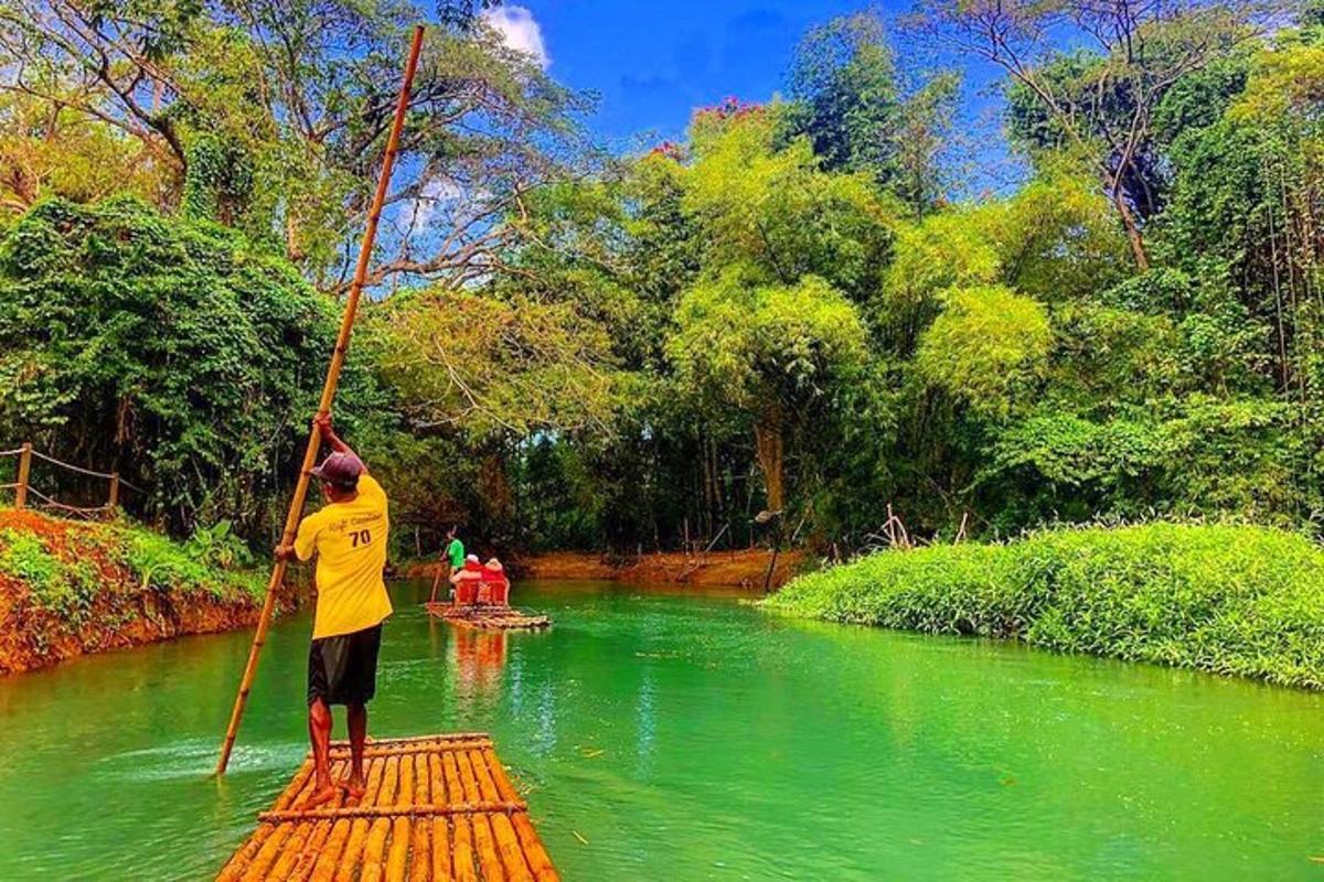 um homem em pé em uma jangada de bambu em um rio