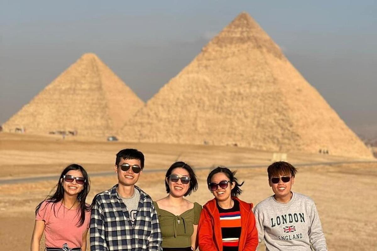 un groupe de personnes debout devant les pyramides