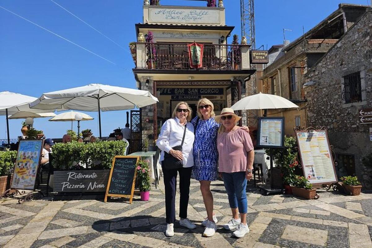 a group of three women standing in front of a building