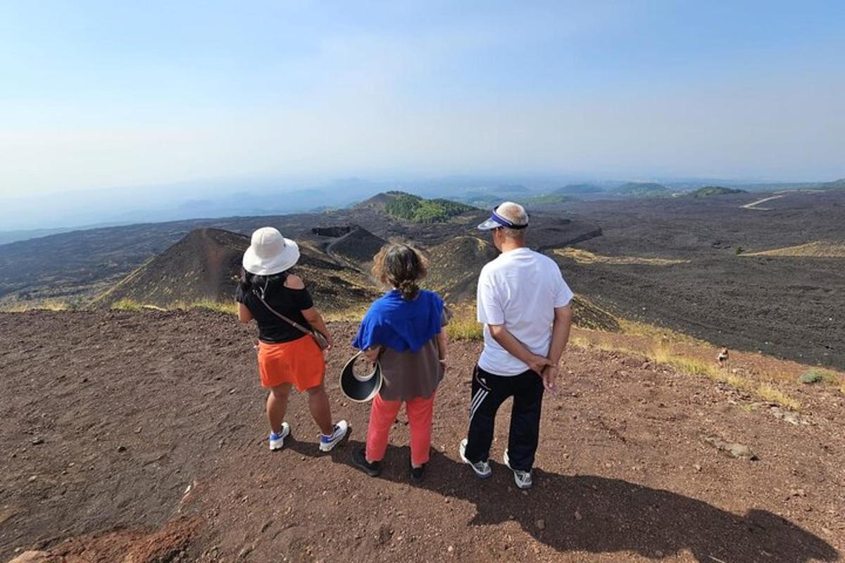 a group of three people standing on top of a hill