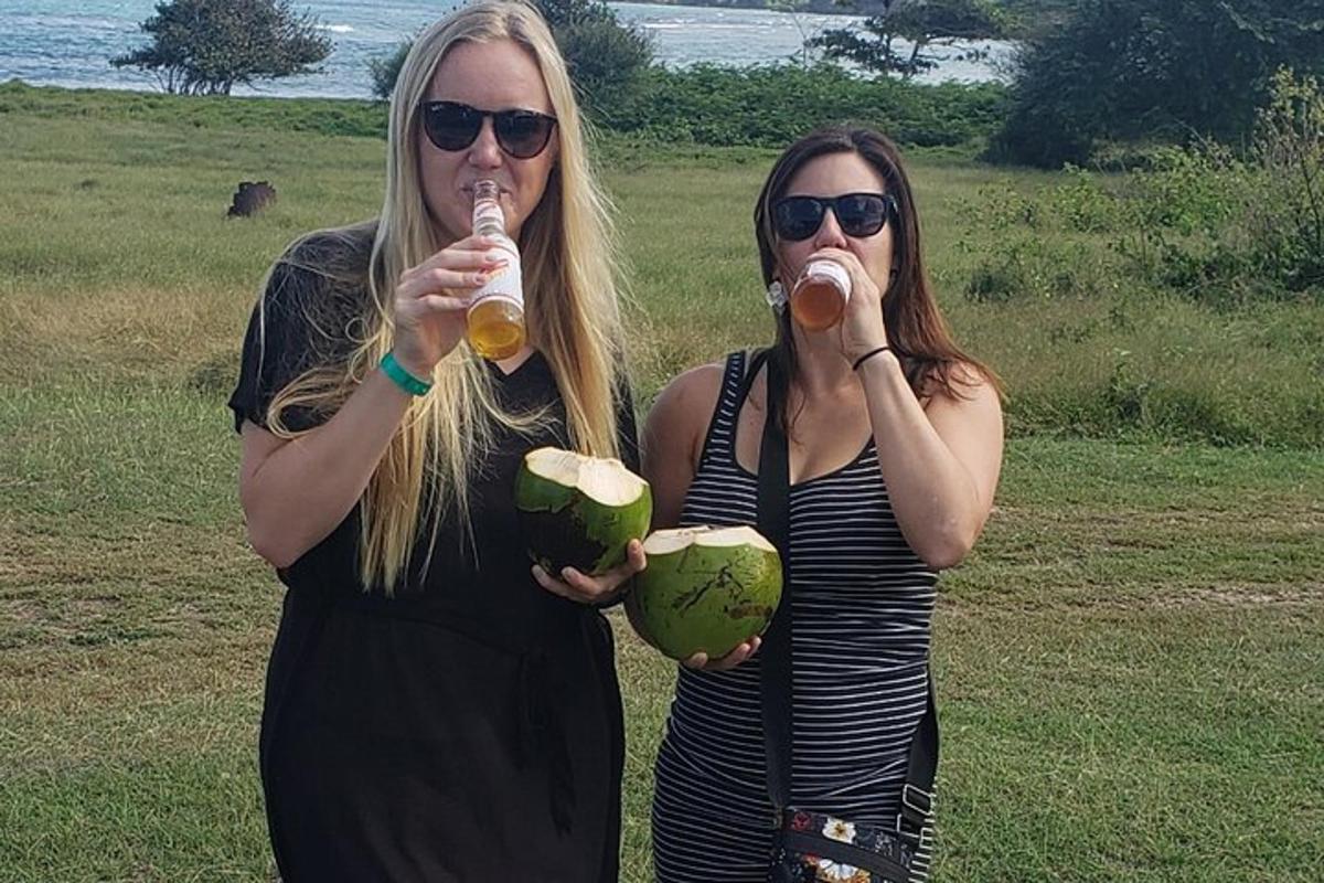 dua wanita minum bir dan makan kelapa di ladang