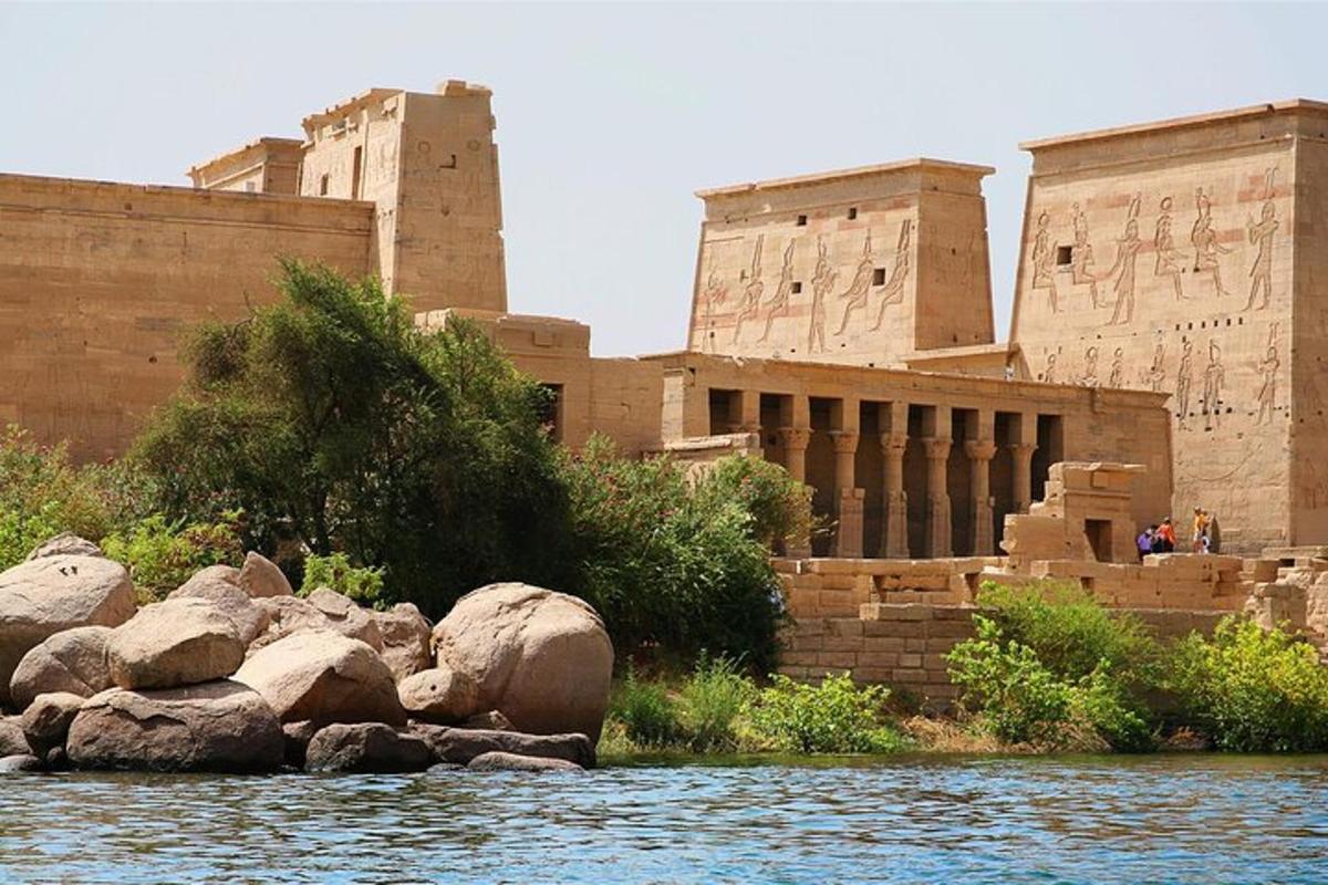 Un edificio al lado de un río con rocas al frente.