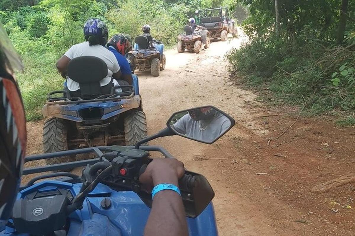un gruppo di persone che guidano quad su una strada sterrata