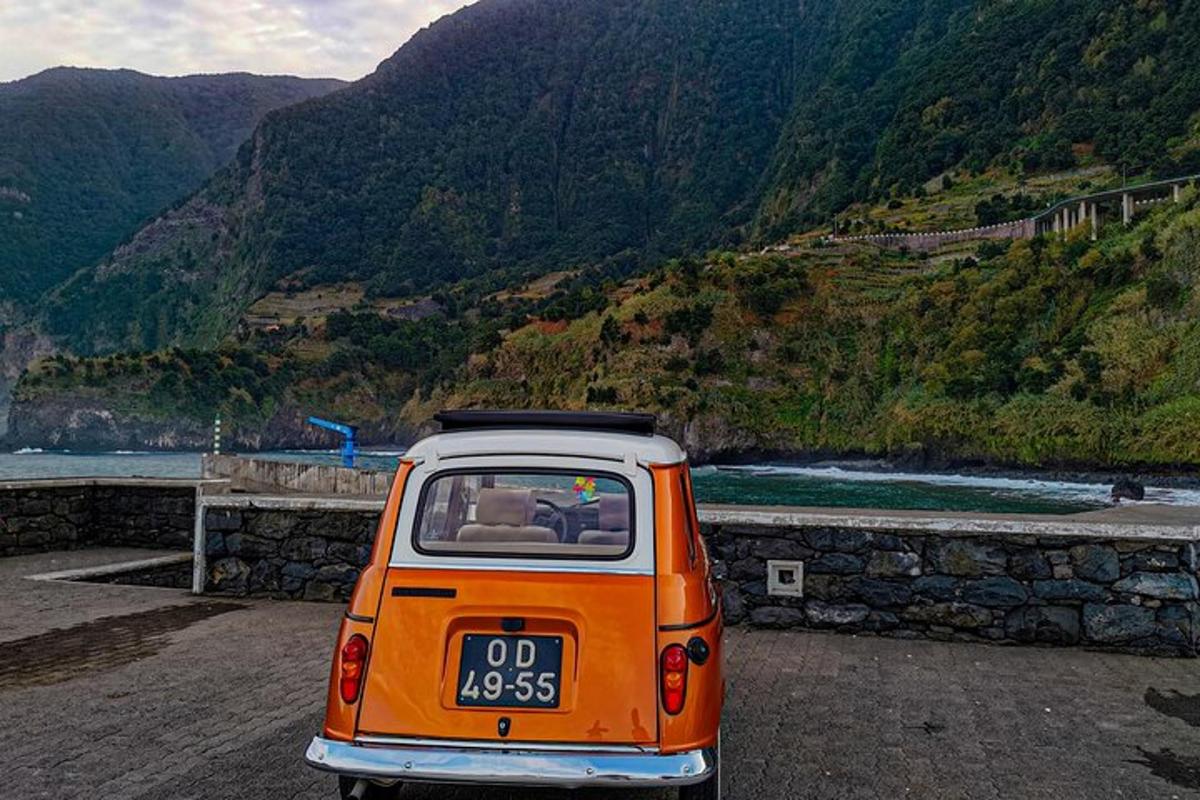 oranžovobílé auto zaparkované vedle hory
