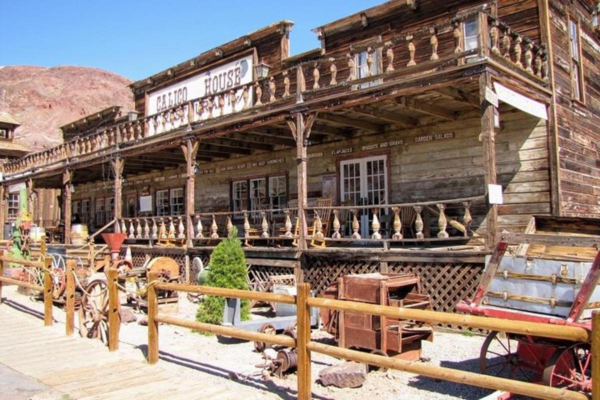 o clădire veche din lemn cu o trăsură trasă de cai în față