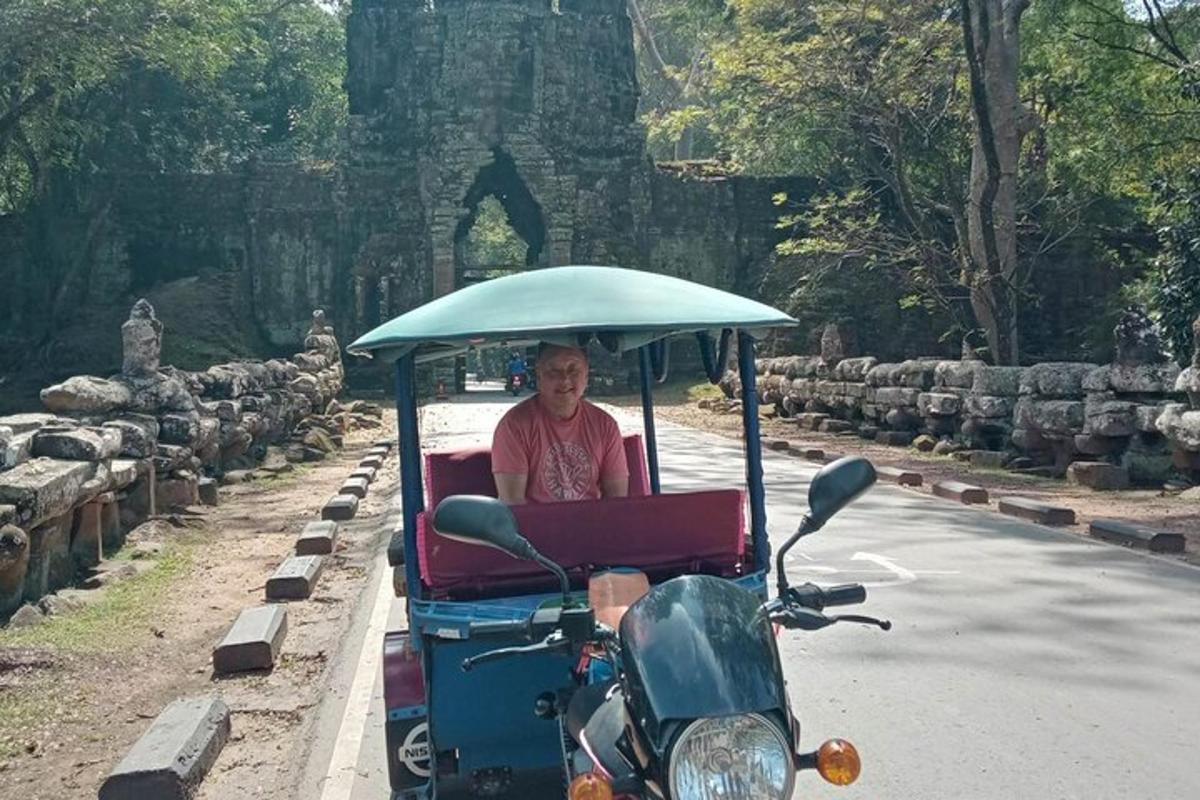 Un hombre conduciendo un carrito de golf por una carretera