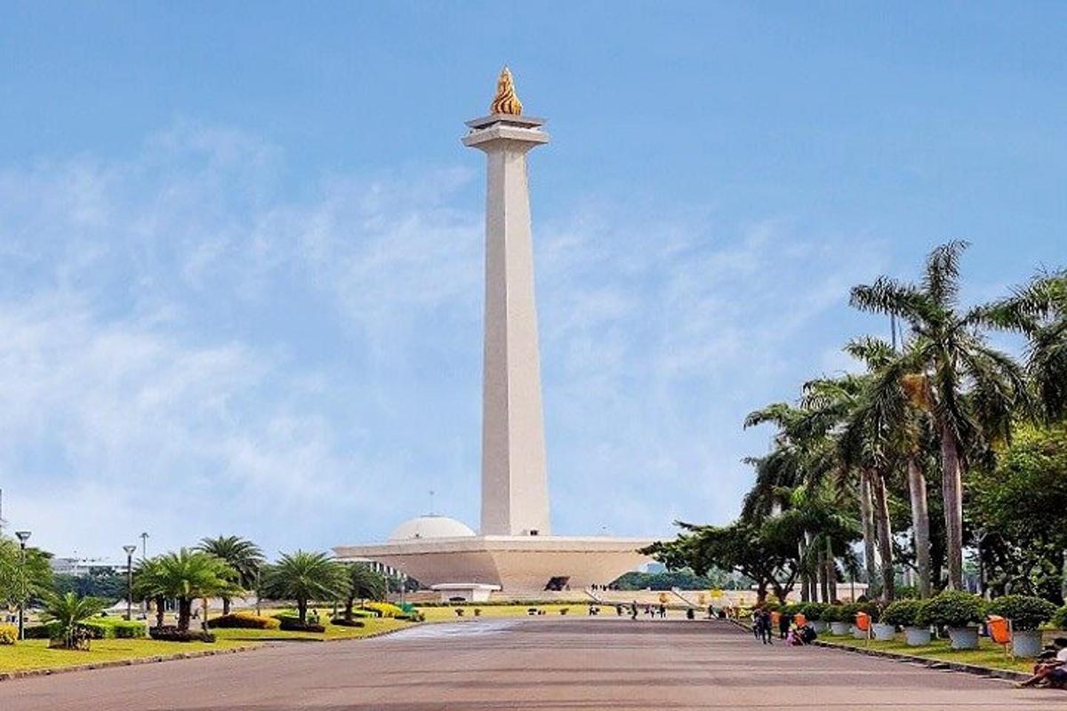 um grande monumento em frente a um edifício com palmeiras