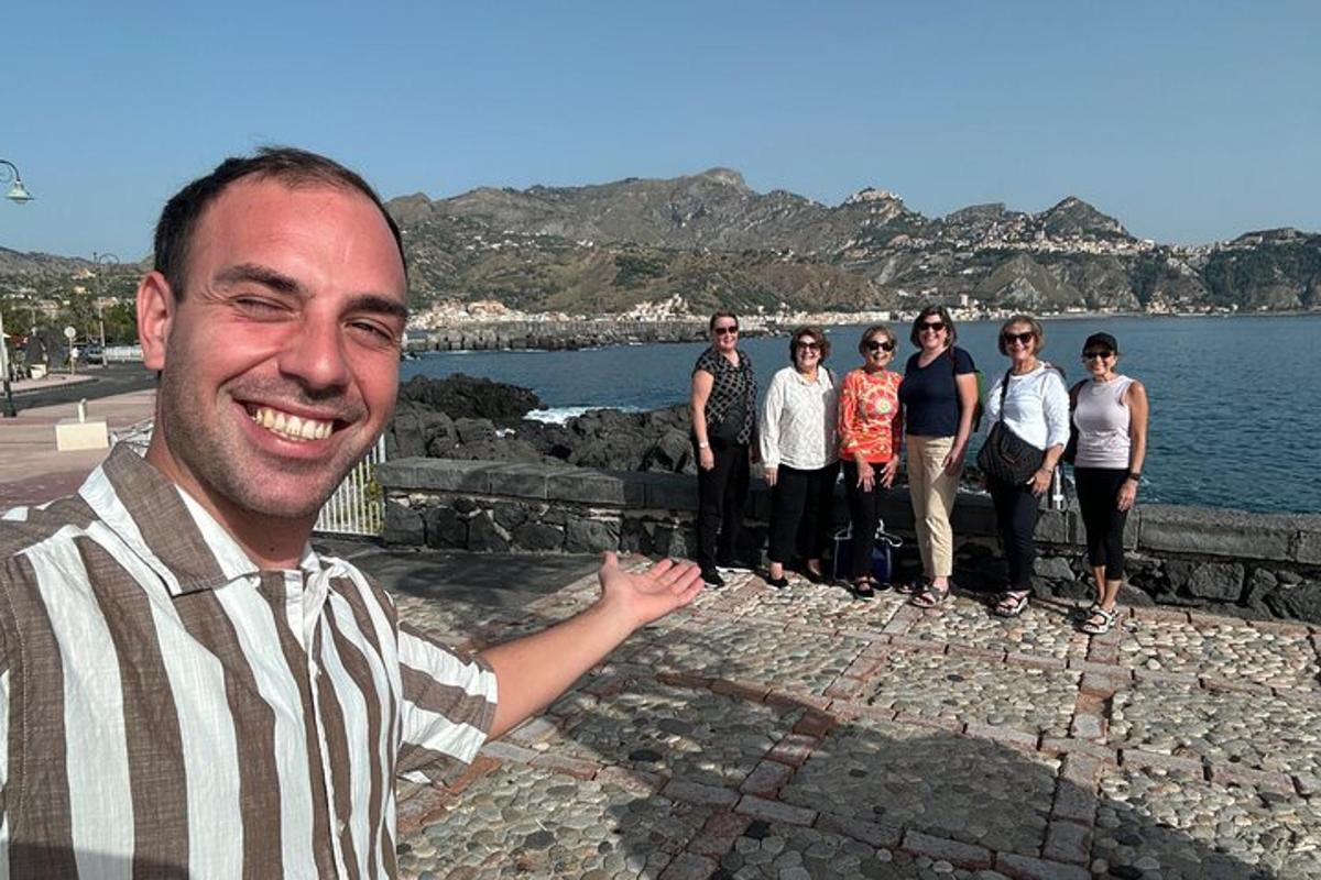 Un hombre de pie junto a un grupo de personas.