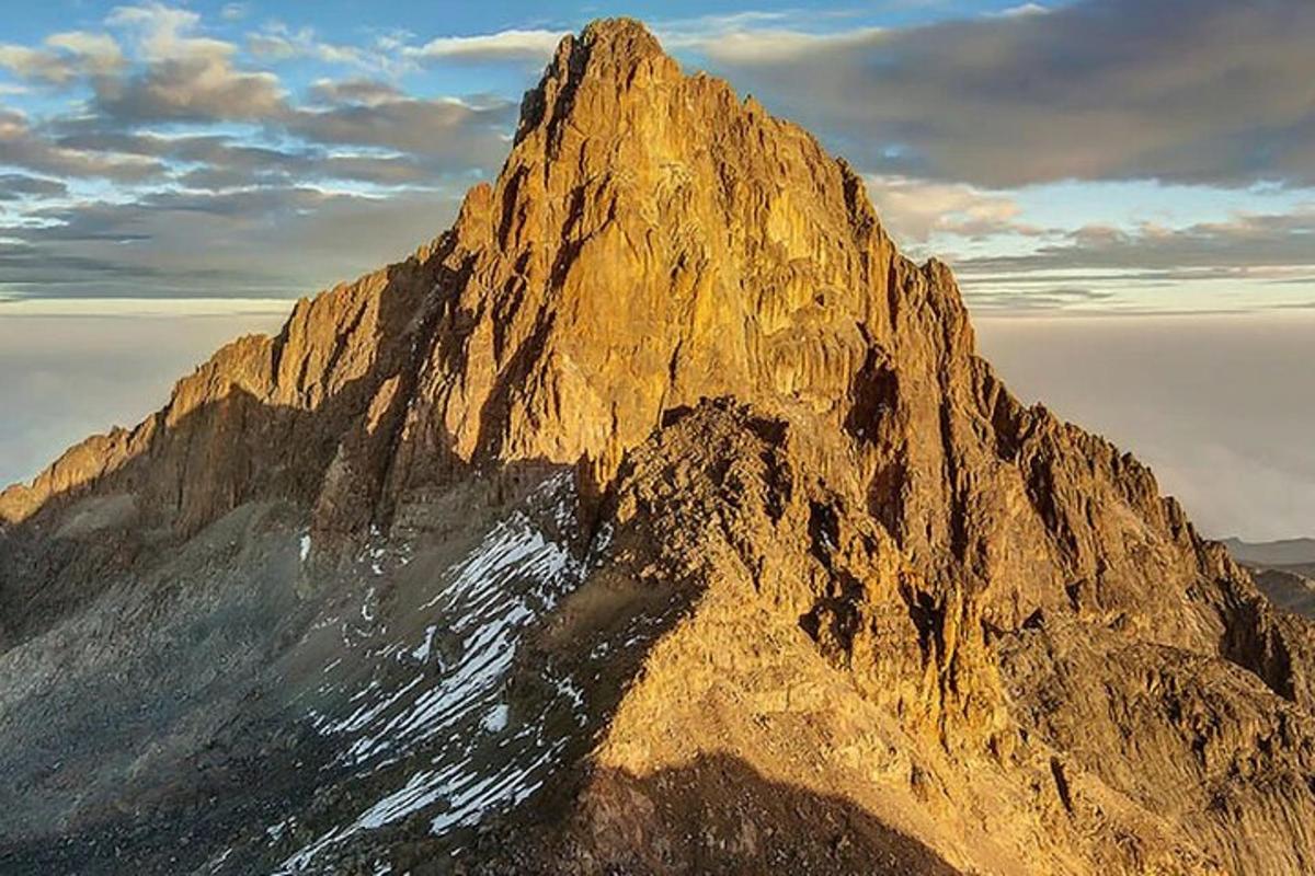pemandangan gunung berbatu besar dengan awan di latar belakang