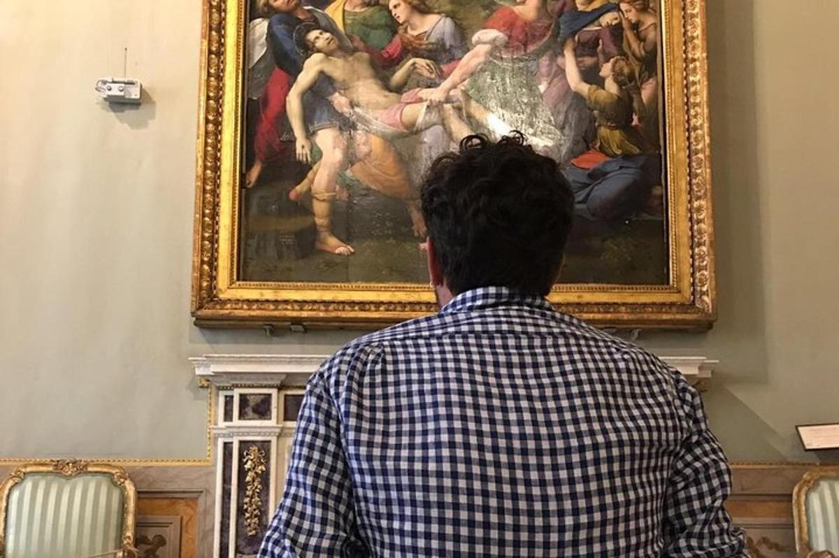 een man die naar een schilderij in een museum kijkt