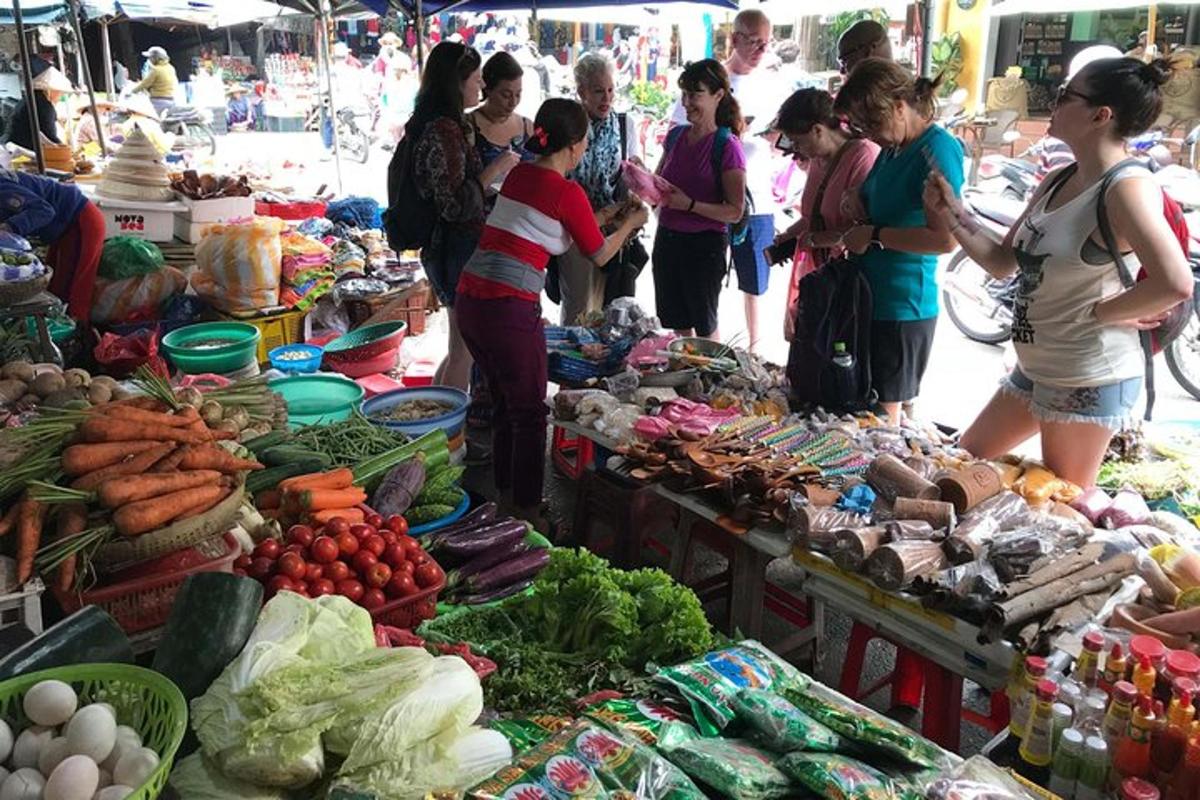 un grup de oameni care stăteau în jurul unei piețe cu legume