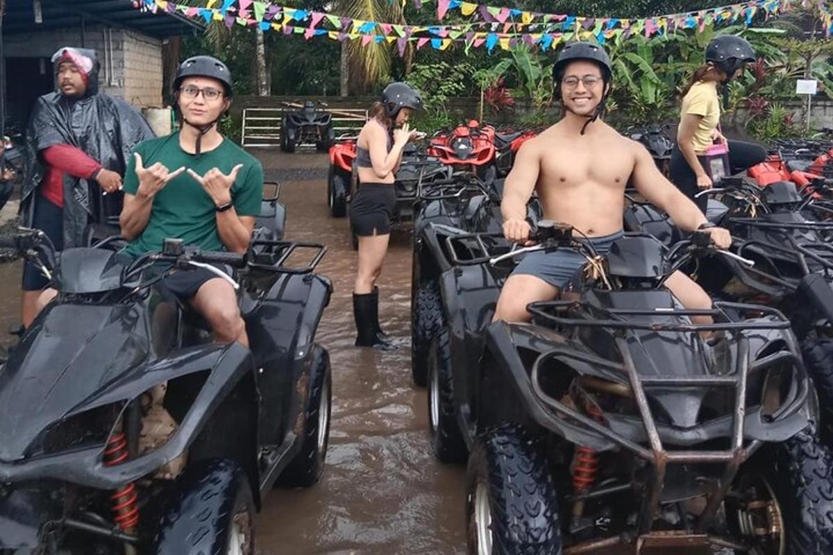 Két férfi ül ATV-ken a sárban