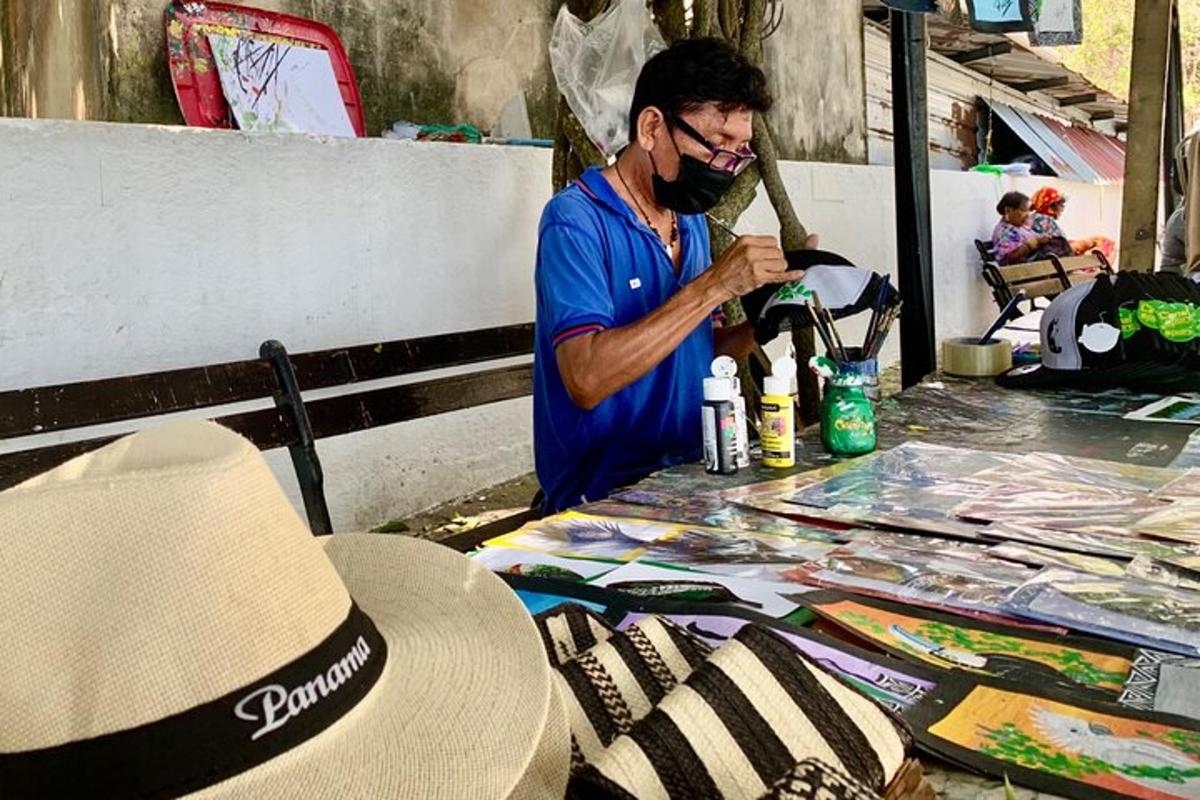 a man standing next to a table with a hat