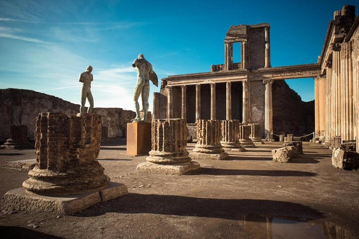 dues estàtues d'homes drets sobre pilars davant d'un edifici