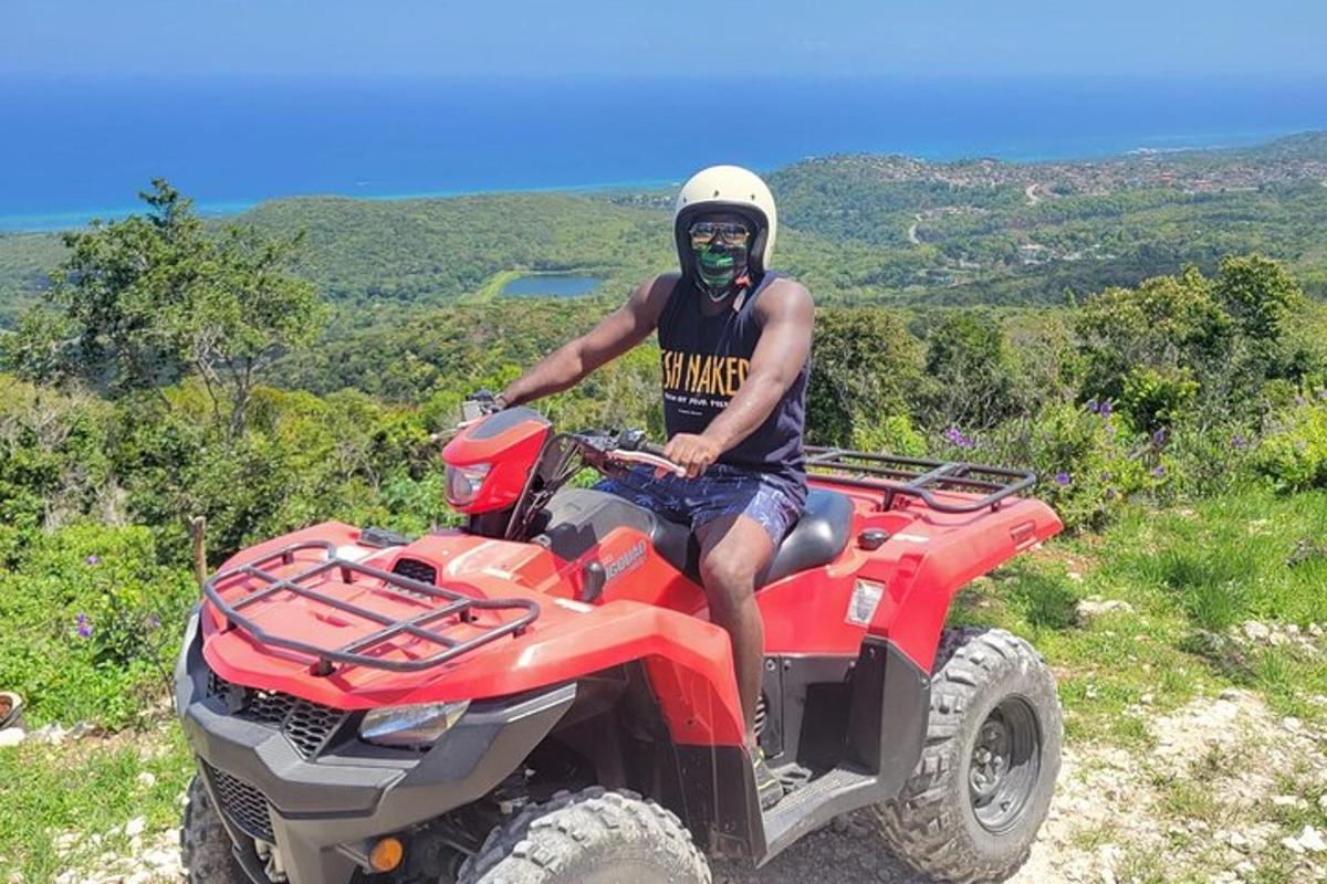 seorang lelaki sedang duduk di atas atv di atas bukit