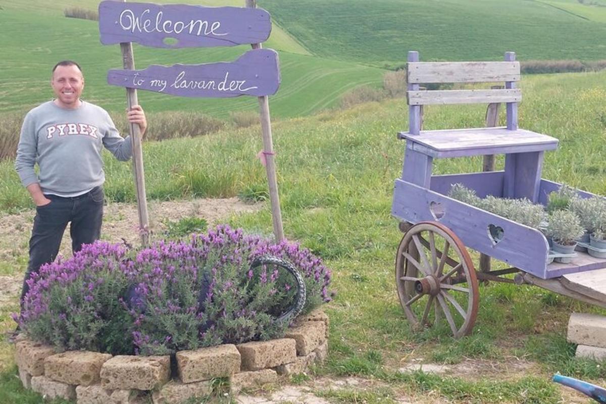 un uomo in piedi accanto a un cartello accanto a un giardino fiorito