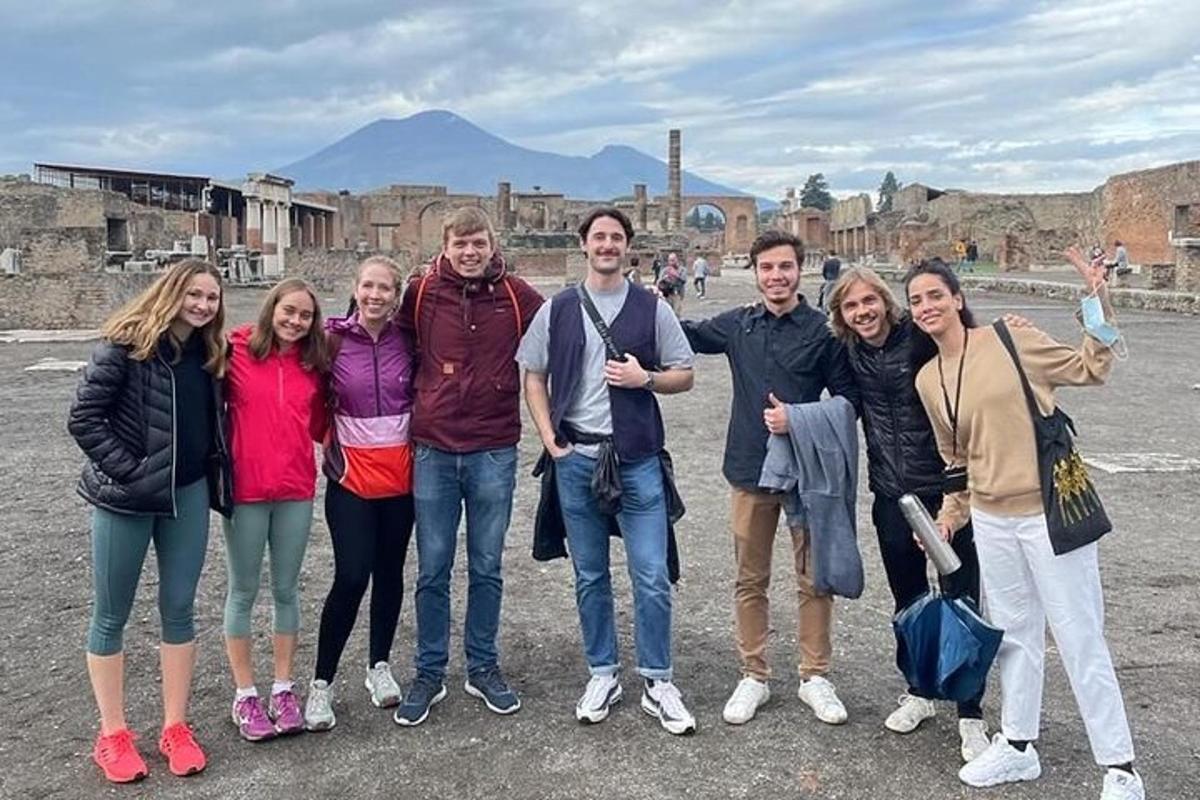 un gruppo di persone in posa per una foto davanti alle rovine