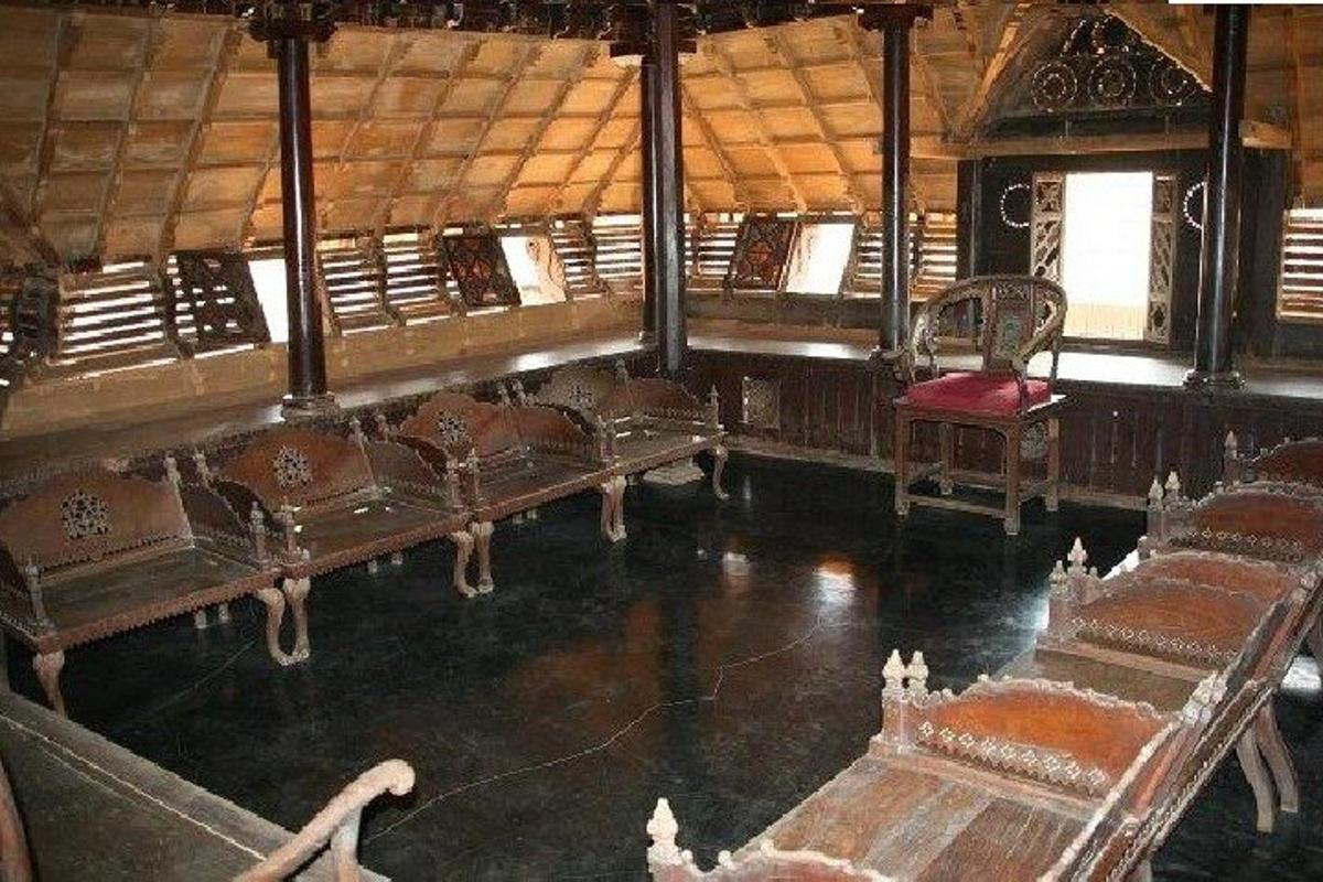 a room with rows of benches and a red chair