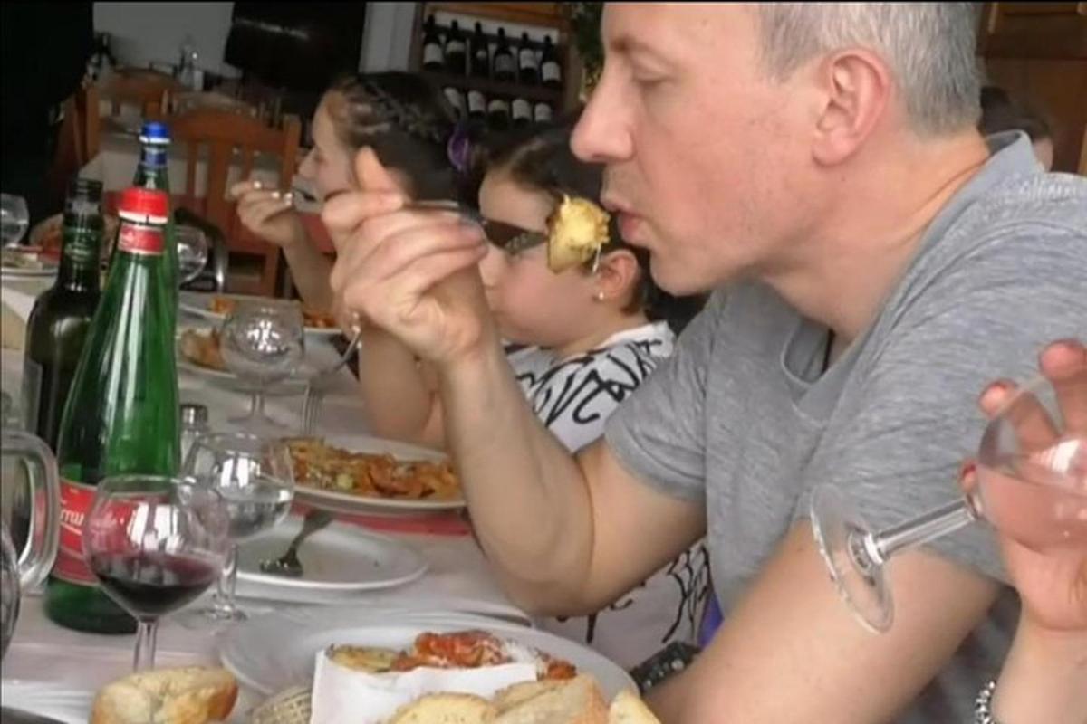 skupina lidí sedících u stolu a jedících