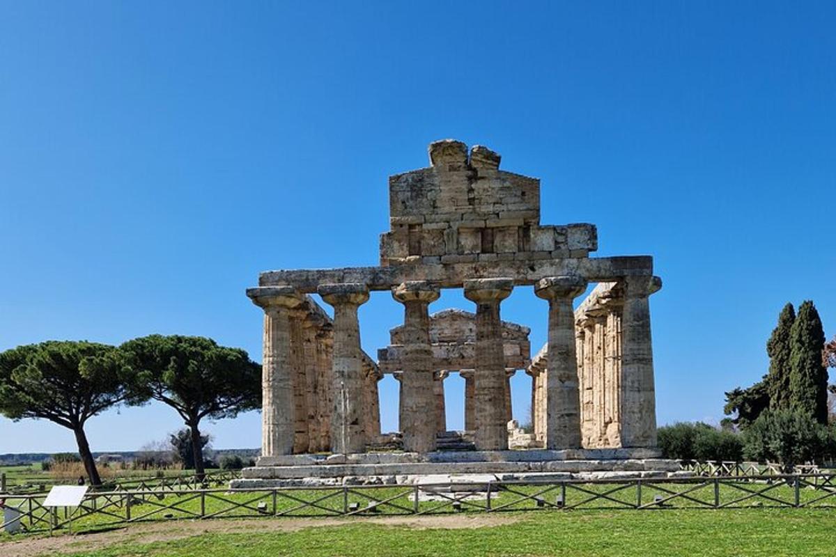 un antico tempio in un campo con un cielo azzurro