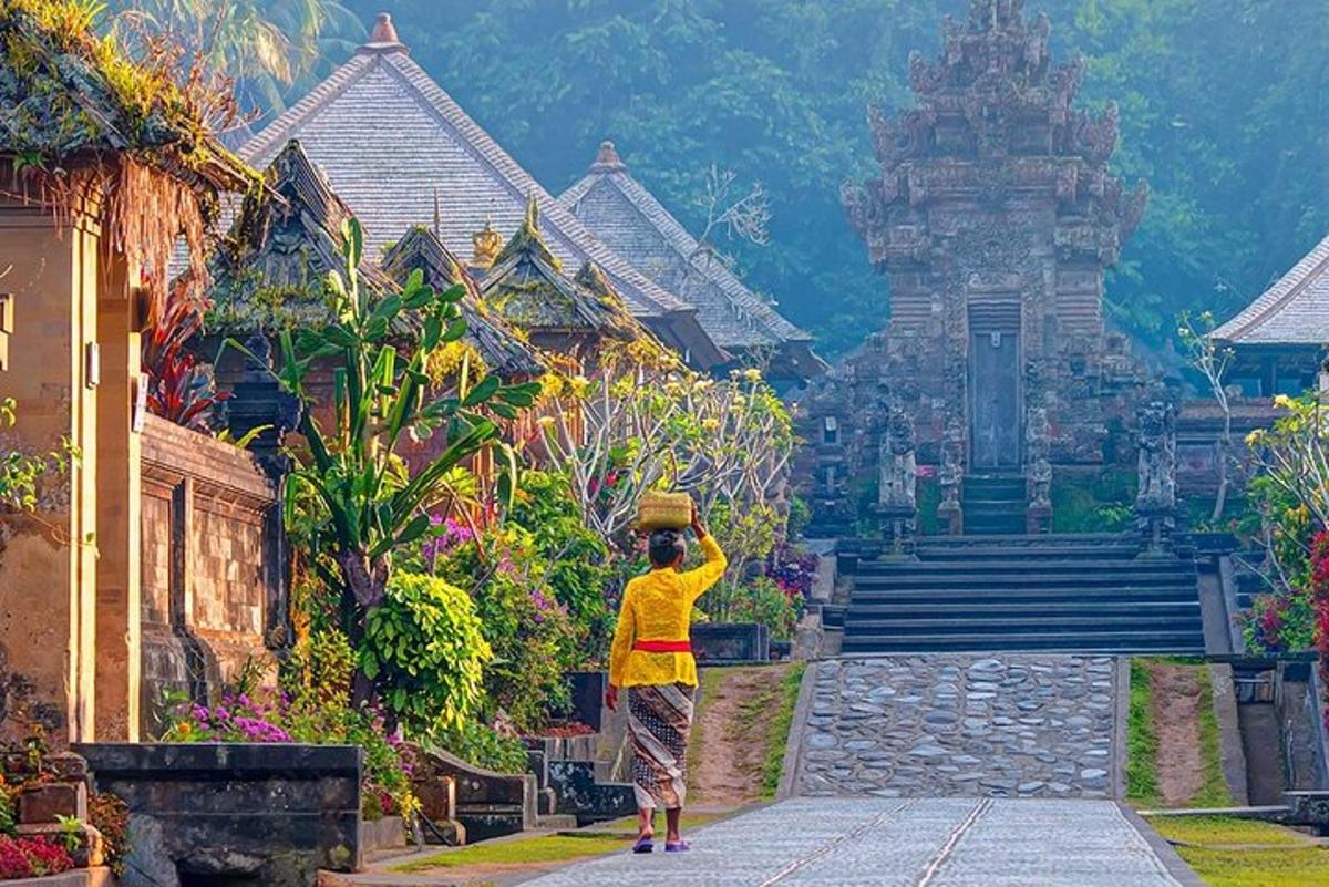 seorang lelaki berdiri di hadapan sebuah bangunan dengan bakul di atas kepalanya