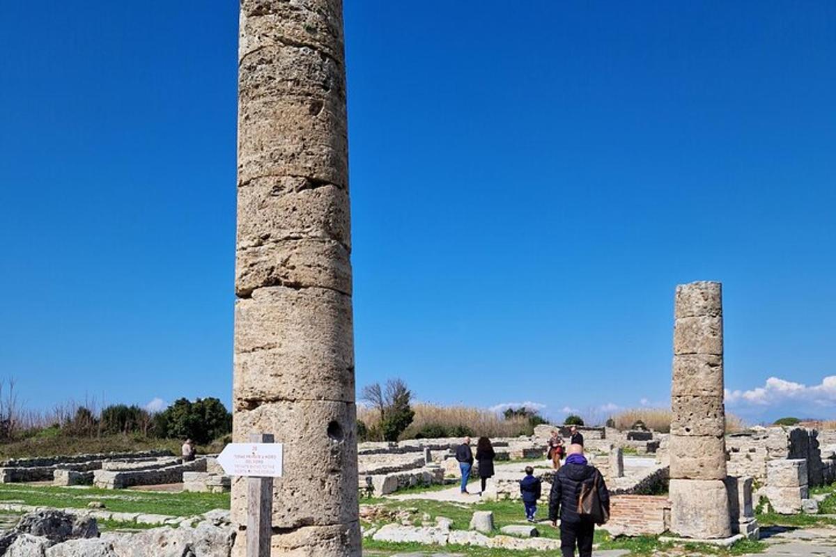 un gruppo di persone che cammina vicino a due rovine