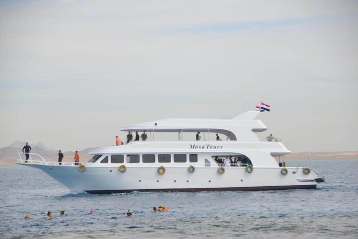 ein Kreuzfahrtschiff im Wasser mit Menschen am Strand