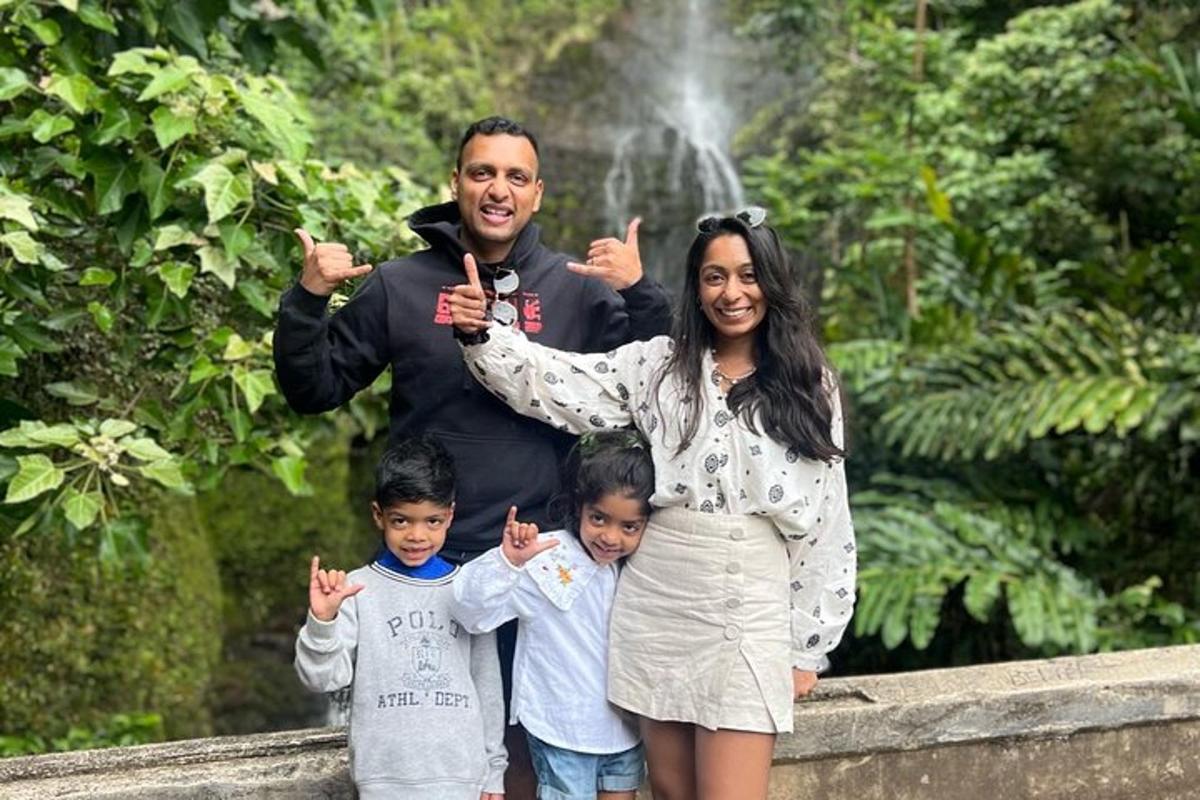 a man and a woman and two children standing in front of a fountain