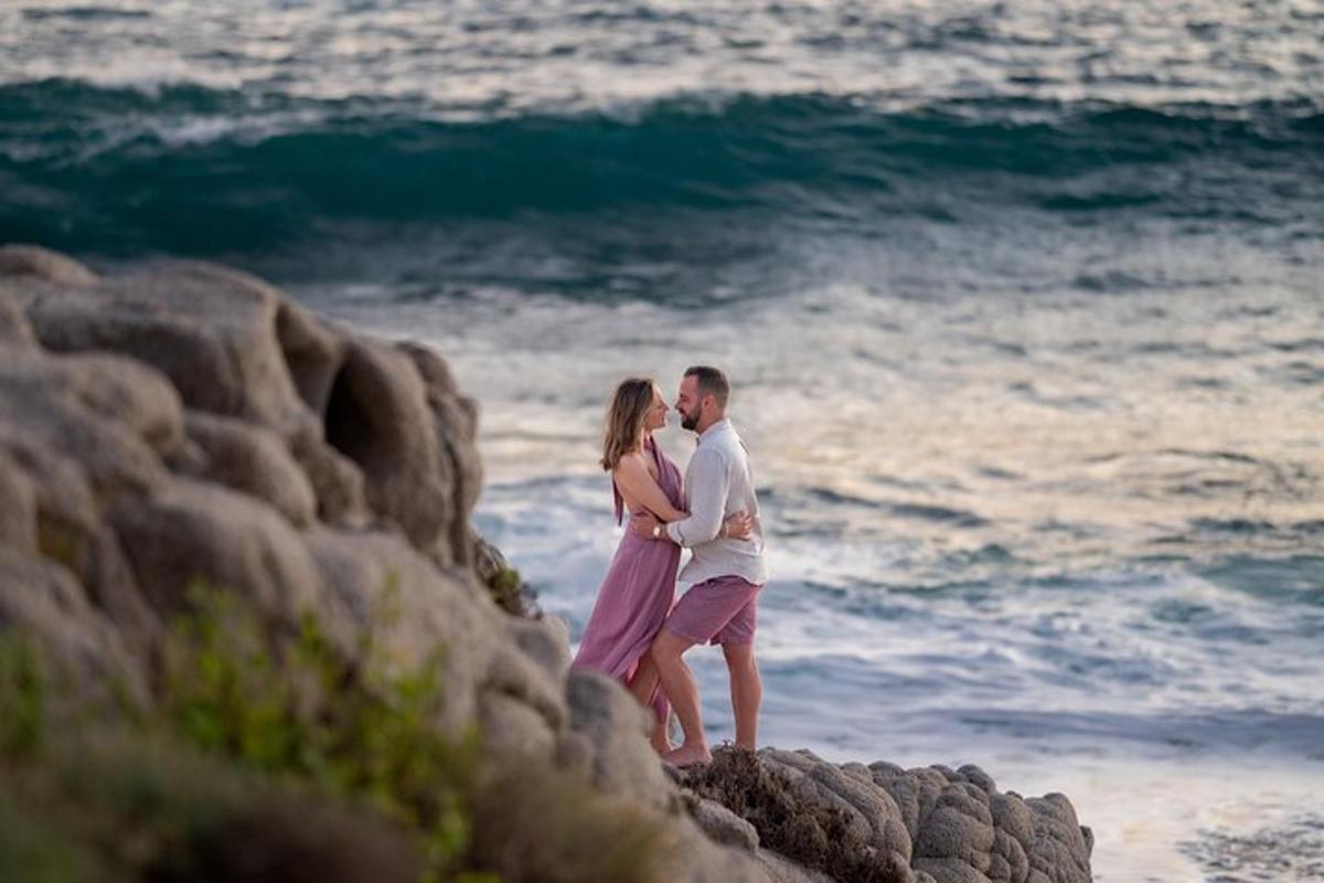 Un hombre y una mujer de pie en una playa rocosa