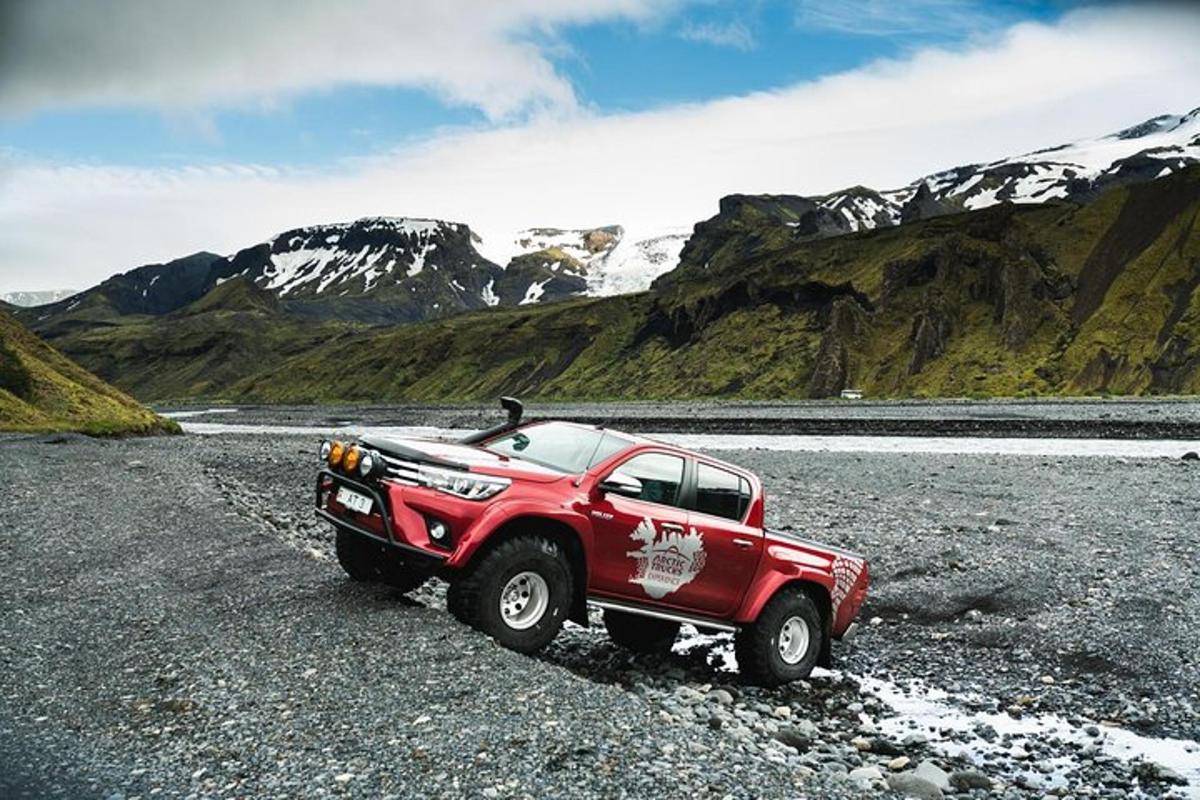 rauður vörubíll lagður við fjallshlíð