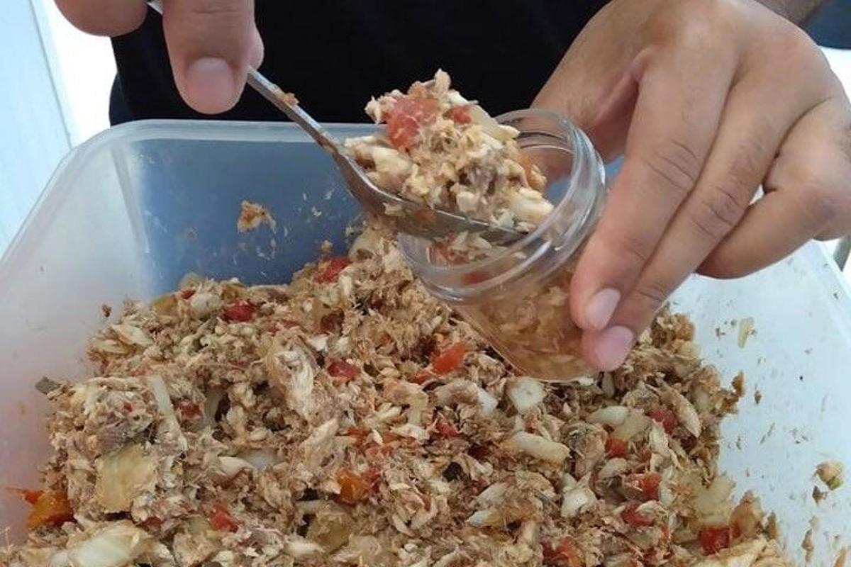 seseorang makan semangkuk makanan dengan sendok