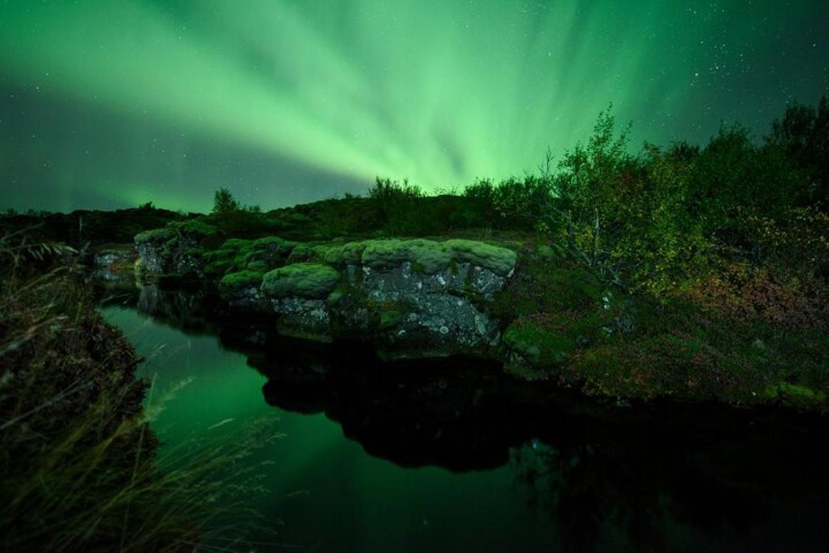 norðurljós yfir vatni með á