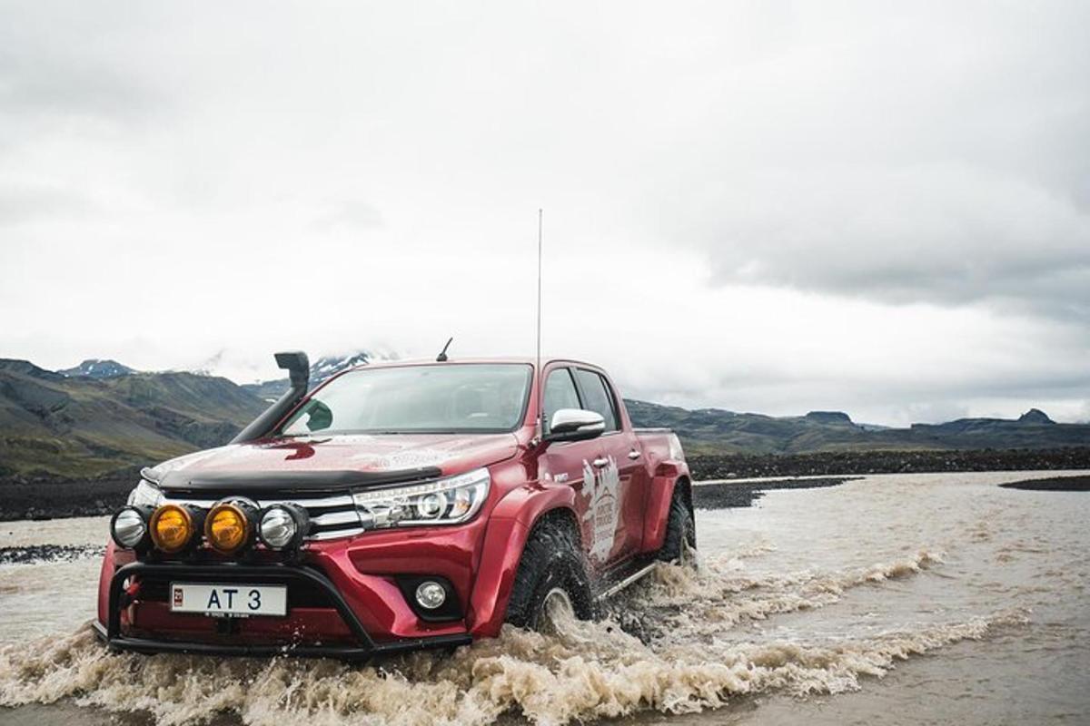 un camión rojo conduciendo por el agua
