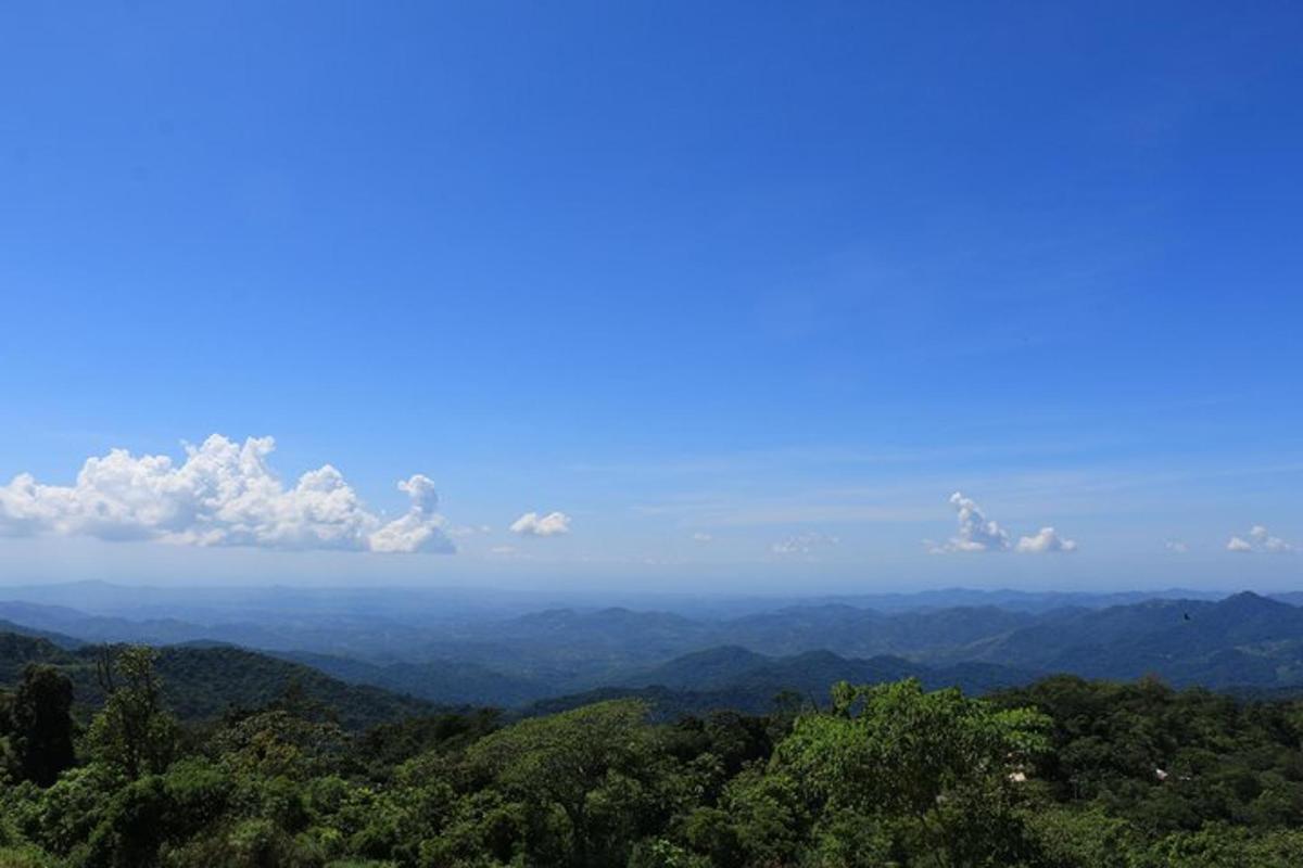 a view of the mountains with a blue sky and clouds