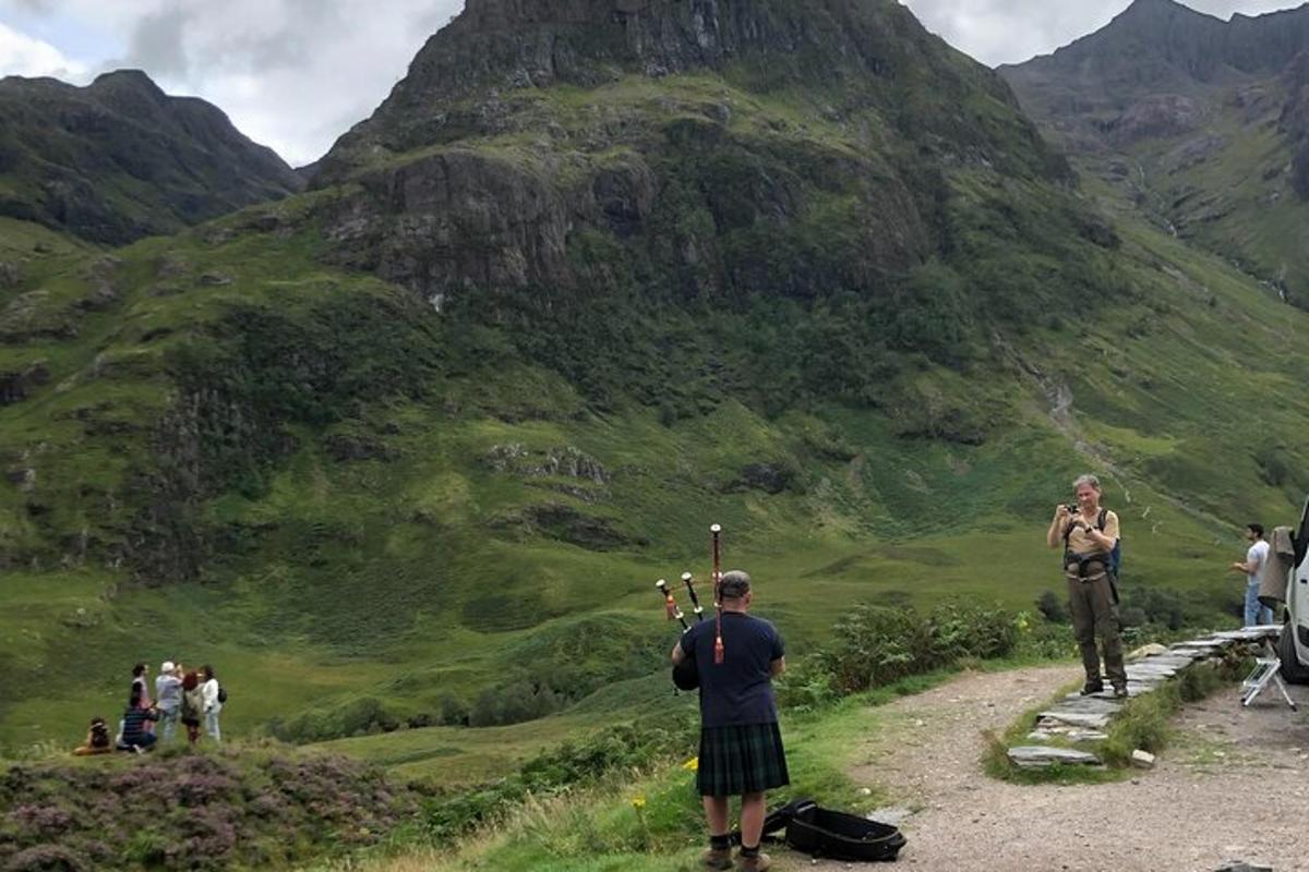 un uomo in piedi su una strada sterrata che guarda una montagna