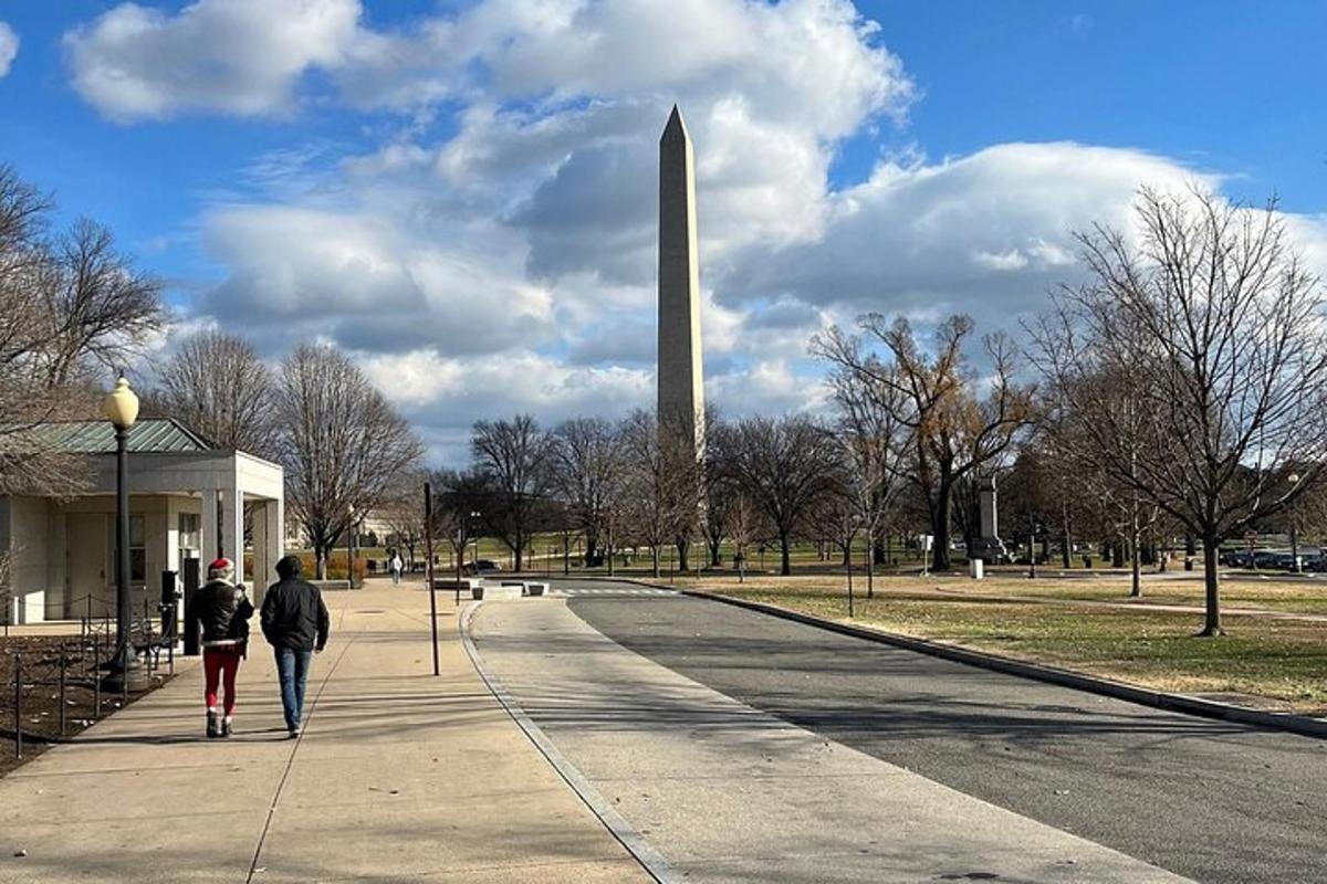 dues persones caminant per una vorera davant d'un monument a Washington