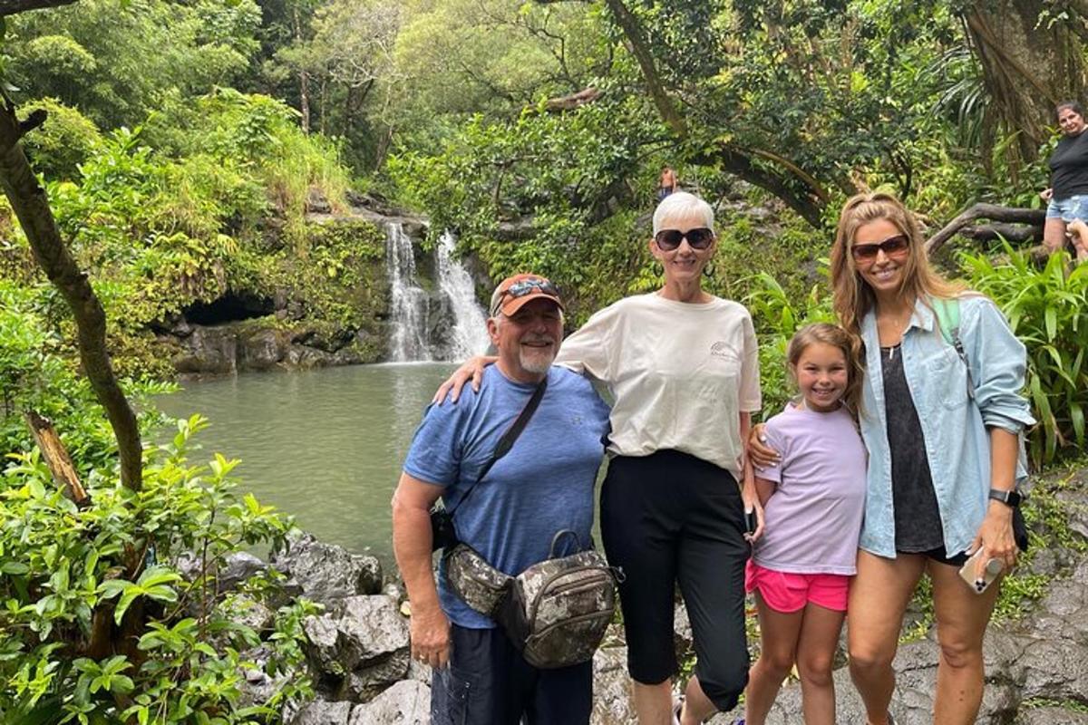 a group of people standing in front of a waterfall