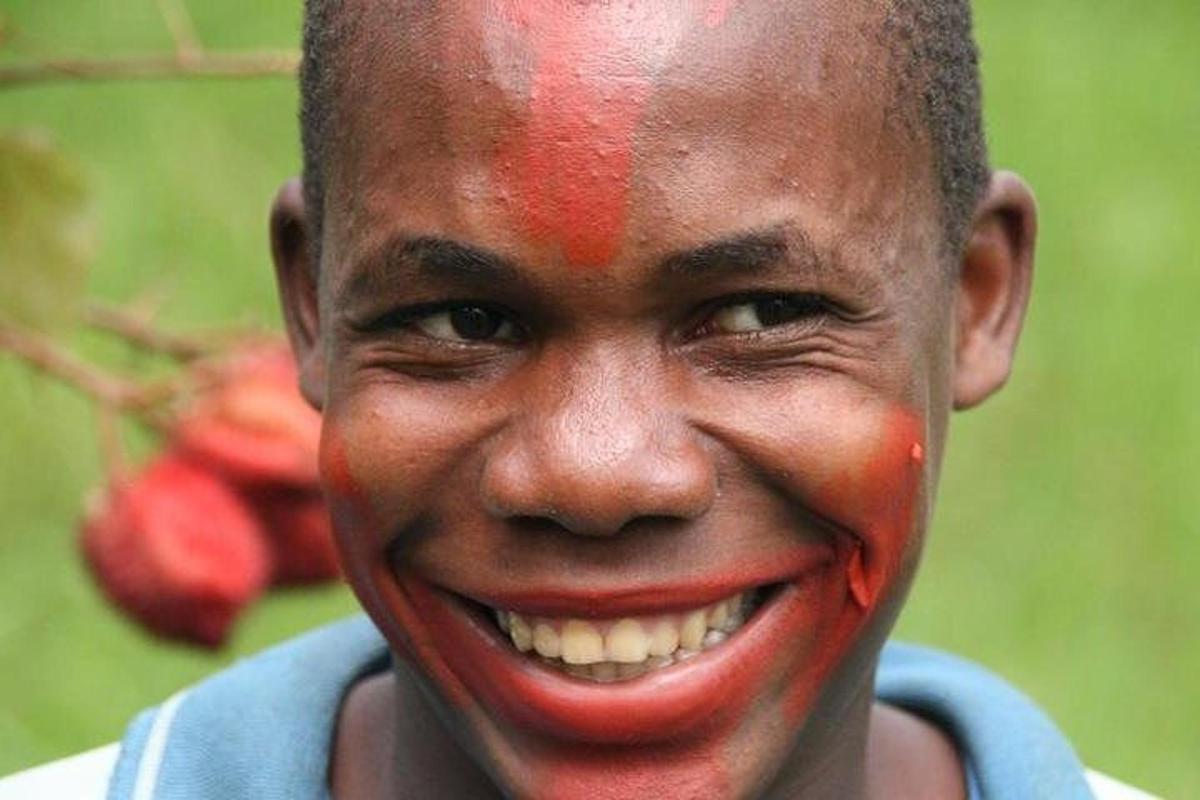 un jeune homme avec de la peinture rouge sur le visage