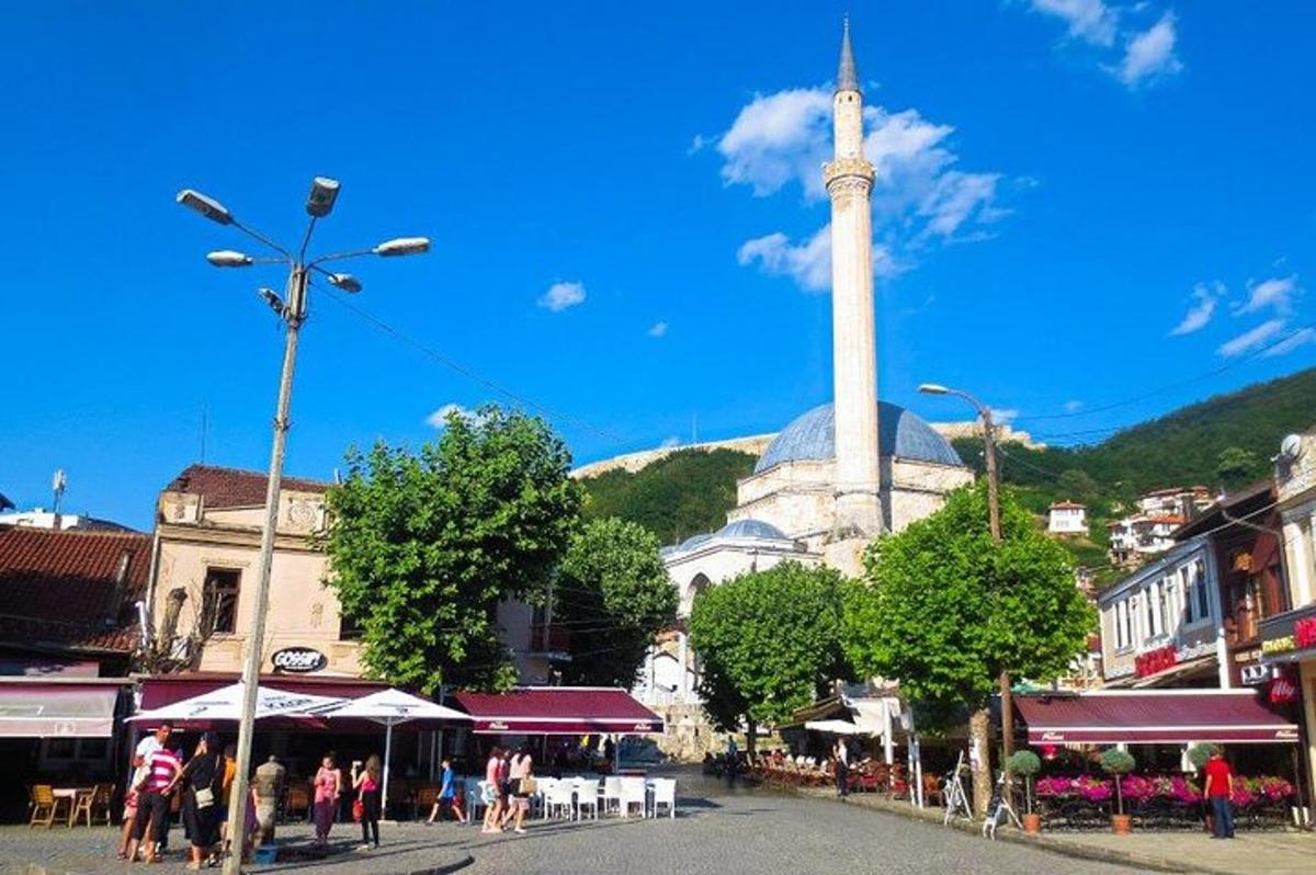 ulica z mošejo v ozadju, naokoli pa se sprehajajo ljudje