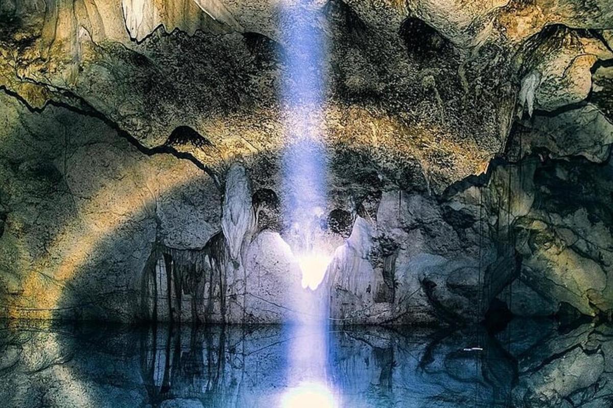 air terjun dalam gua dengan orang berdiri di dalam air
