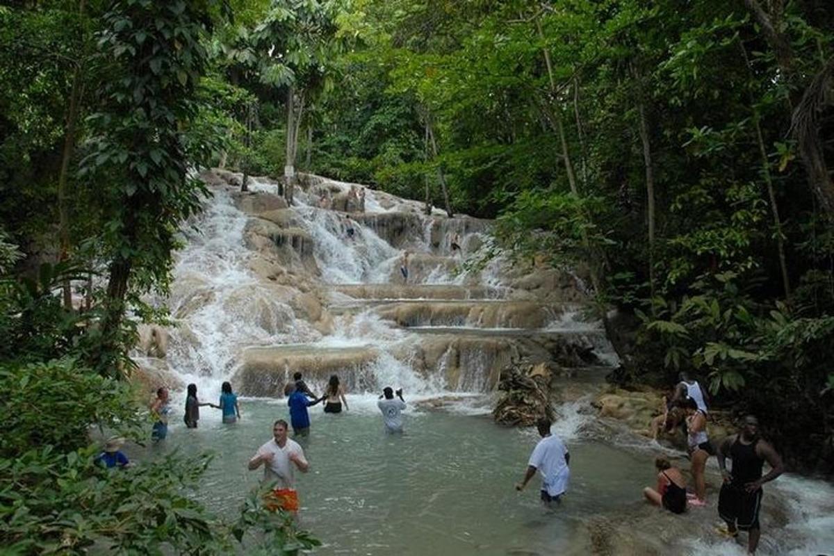 sekumpulan orang di dalam air berhampiran air terjun